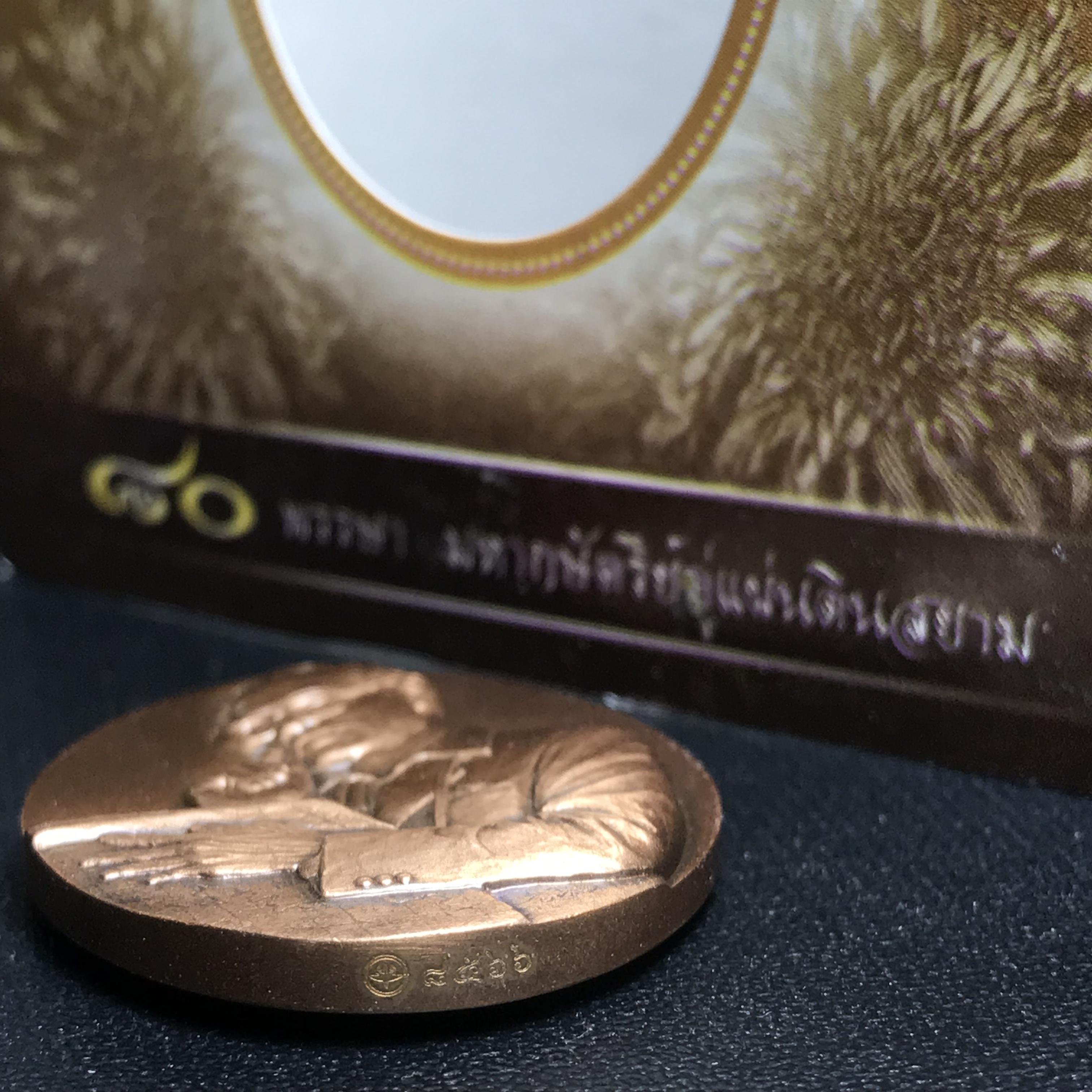 เหรียญรูปหล่อพระบาทสมเด็จพระเจ้าอยู่หัว ในหลวงทรงงาน “รุ่นเย็นศิระเพราะพระบริบาล 80พรรษา มหากษัตริย์คู่แผ่นดินสยาม” พ.ศ.2550 เนื้อทองแดงรมดำ(ขนาด 27*35 มม.)พร้อมกล่องบรรจุเดิมครบ