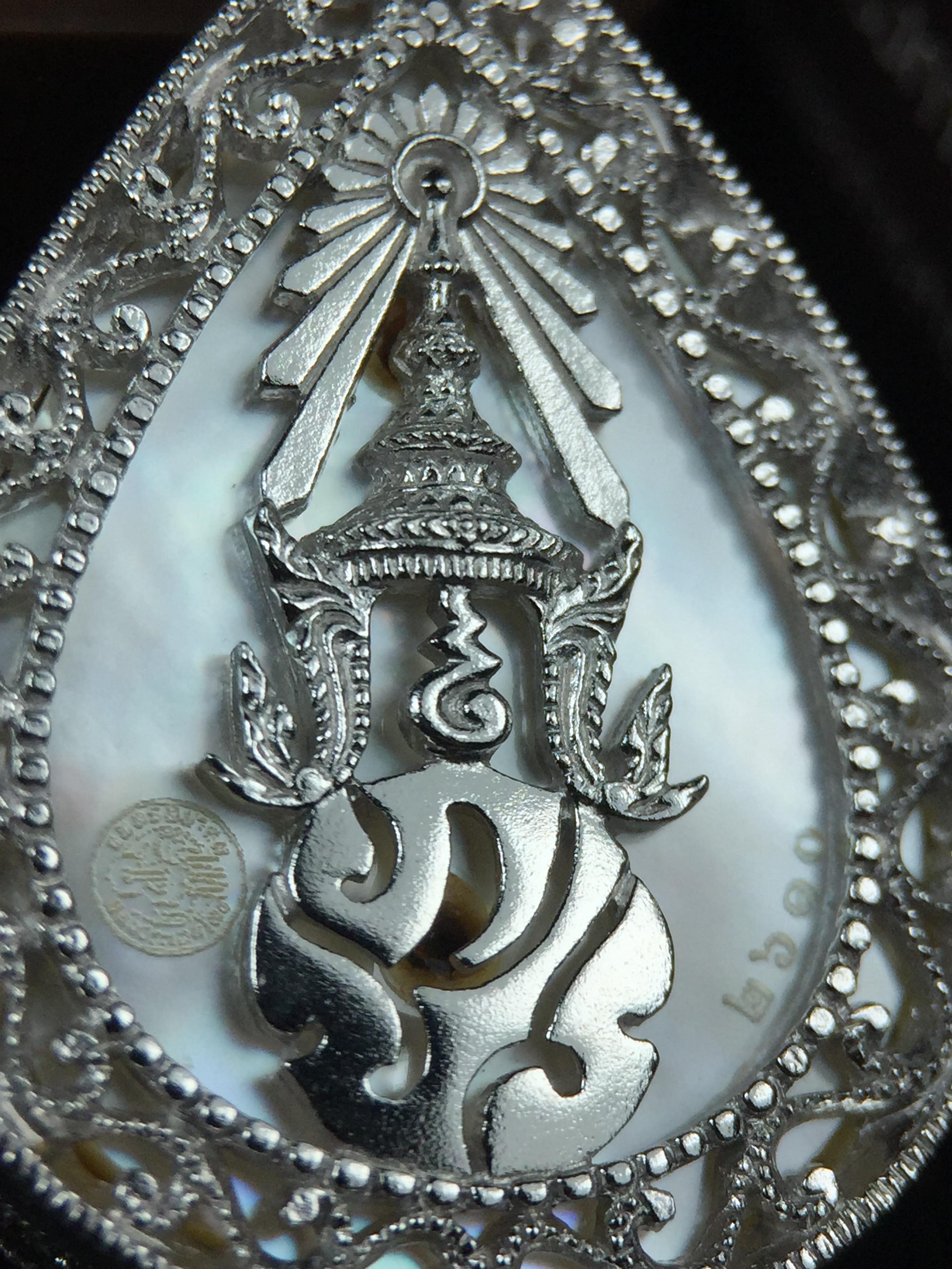 พระพุทธชินราช ภปร. โครงการ "เพราะแผ่นดินนี้ คือ แผ่นดินเกิด" ปี2548(รุ่นแรก) เหรียญทรงหยดน้ำ ขนาด 21 x 31 มม. เนื้อเงินสามกษัตริย์ องค์พระชุบสามกษัตริย์ ล้อมด้วยกรอบเงินชุบทองคำขาวสลักเสลาเป็นลวดลายละเอียดอ่อน ส่วนพื้นองค์พระเป็นเปลือกหอยมุข