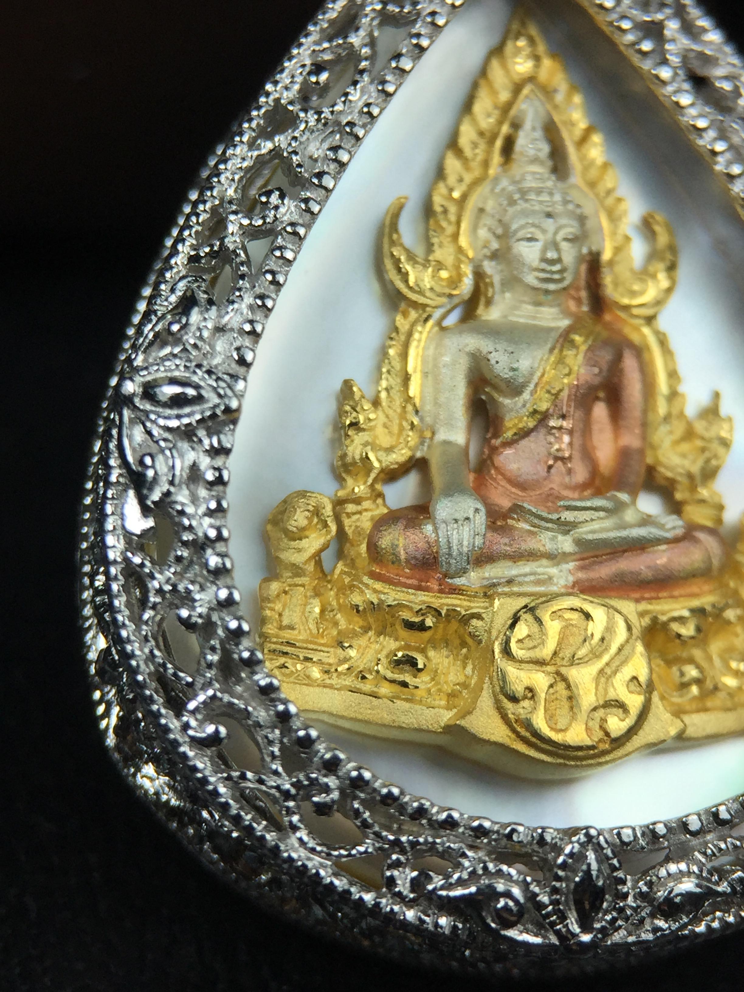 พระพุทธชินราช ภปร. โครงการ "เพราะแผ่นดินนี้ คือ แผ่นดินเกิด" ปี2548(รุ่นแรก) เหรียญทรงหยดน้ำ ขนาด 21 x 31 มม. เนื้อเงินสามกษัตริย์ องค์พระชุบสามกษัตริย์ ล้อมด้วยกรอบเงินชุบทองคำขาวสลักเสลาเป็นลวดลายละเอียดอ่อน ส่วนพื้นองค์พระเป็นเปลือกหอยมุข