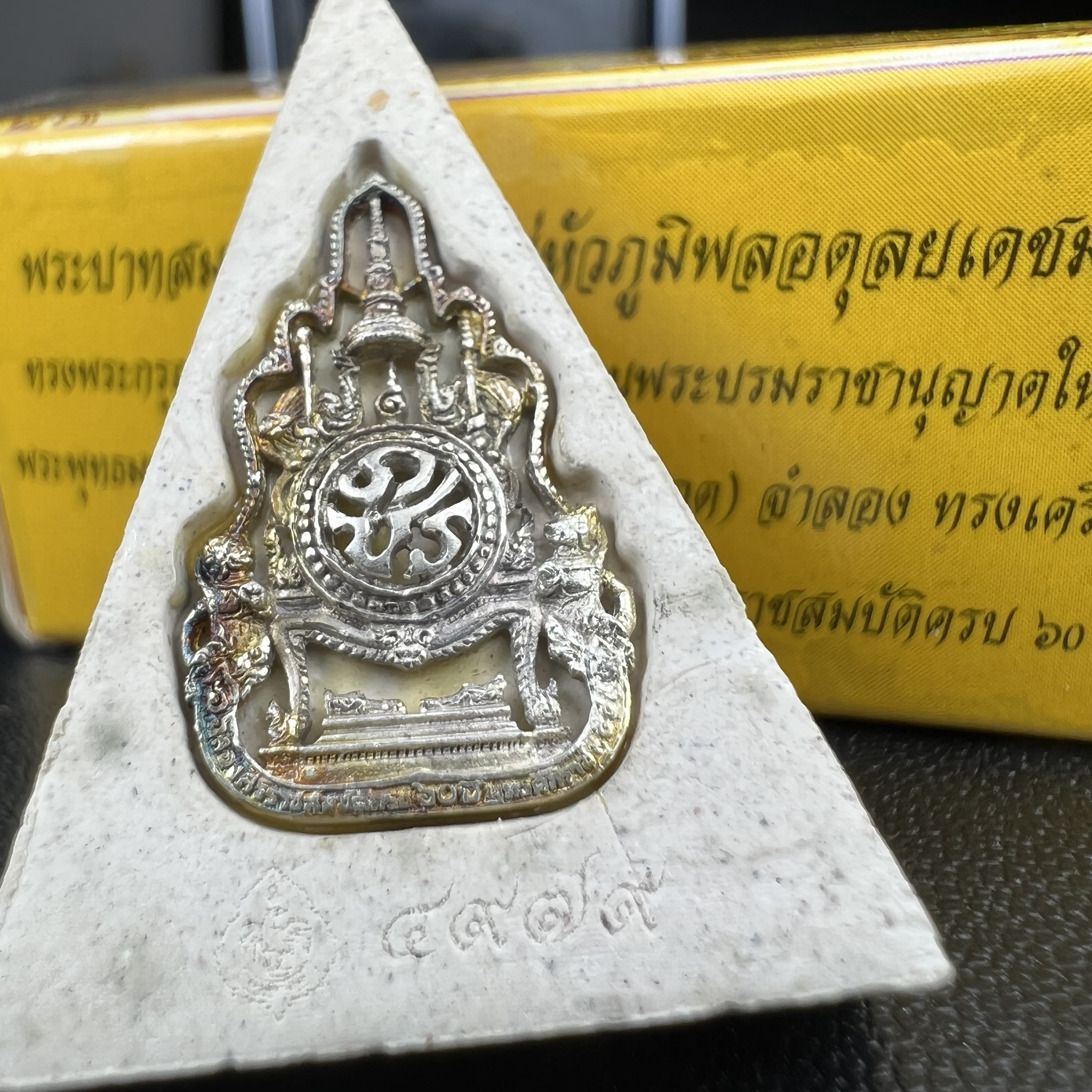 พระแก้วมรกต(จำลอง)ทรงเครื่องฤดูร้อน พระผงบูชา ด้านหน้าปิดทอง ด้านหลังตราสัญลักษณ์ฉลองสิริราชสมบัติครบ 60ปี เนื้อเงิน(รุ่นนี้ได้พระราชทานเส้นพระเจ้า(เส้นผม)รัชกาลที่9ในการจัดสร้าง)