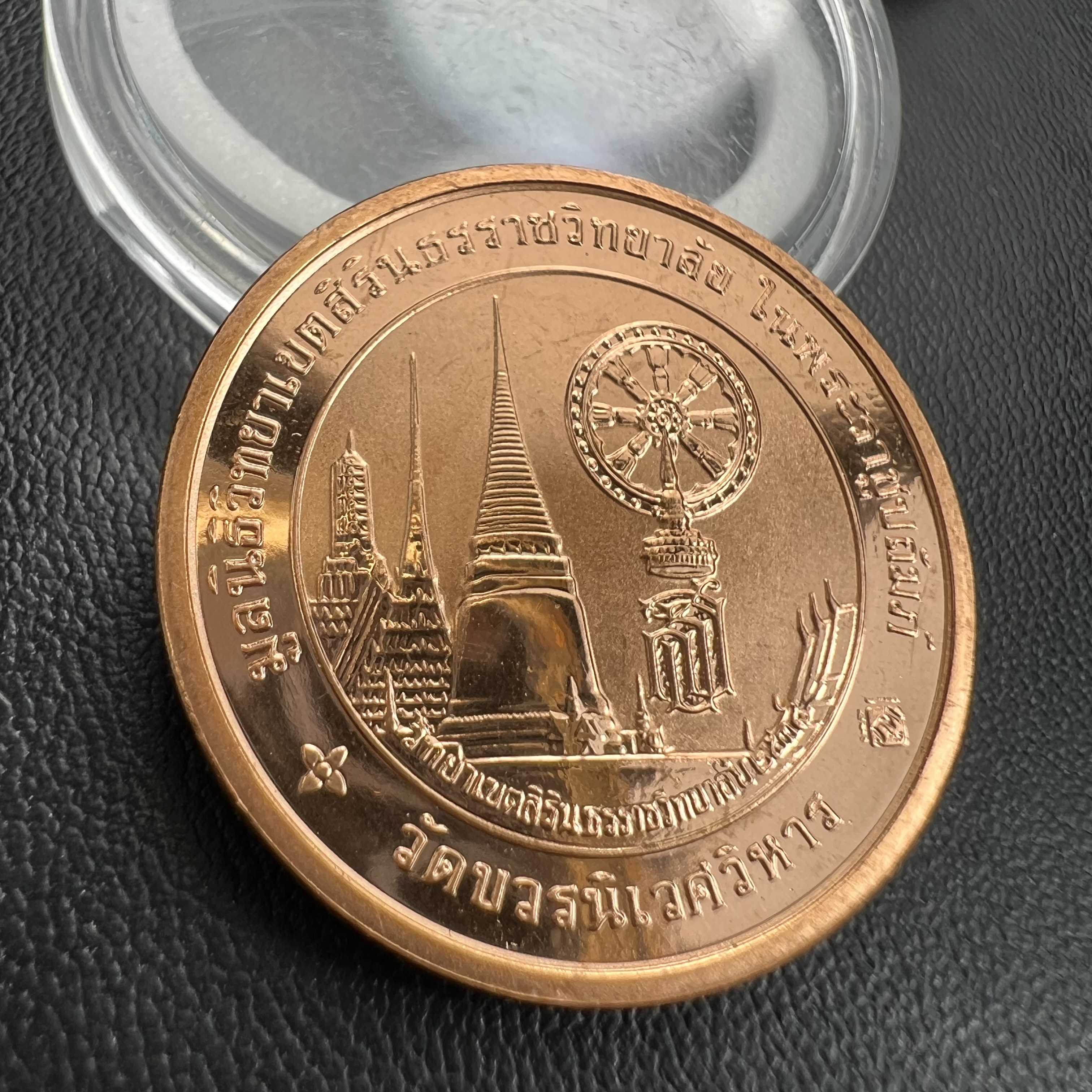 เหรียญพระแก้วมรกต ทรงเครื่องฤดูหนาว หลัง สธ.รุ่นเฉลิมพระเกียรติ ออกโดยมูลนิธิวิทยาเขตสิรินธรราชวิทยาลัย ในพระบรมราชูปถัมภ์ วัดบวรนิเวศวิหาร ปี 2538 เนื้อทองแดงบริสุทธิ์ 99.50% ขัดเงาสามมิติ ขนาด 2.7 ซม.ผลิตโดยโรงกษาปณ์ POB JOY MINT LTD.UK ประเทศอังกฤษ(เหร