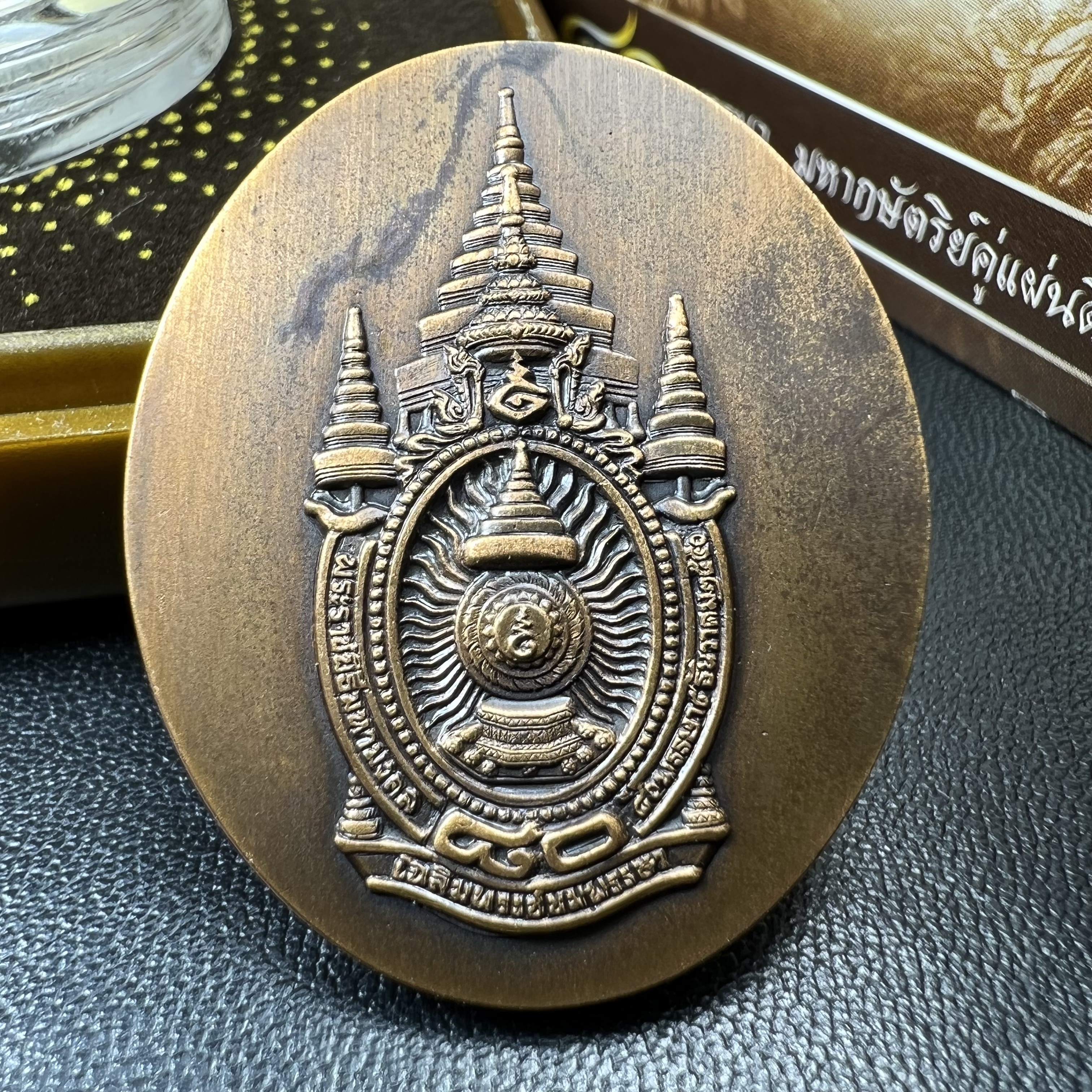 เหรียญรูปหล่อพระบาทสมเด็จพระเจ้าอยู่หัว ในหลวงทรงงาน “รุ่นเย็นศิระเพราะพระบริบาล 80พรรษา มหากษัตริย์คู่แผ่นดินสยาม” พ.ศ.2550 เนื้อทองแดงรมดำ(ขนาด 27*35 มม.)พร้อมกล่องบรรจุเดิมครบ