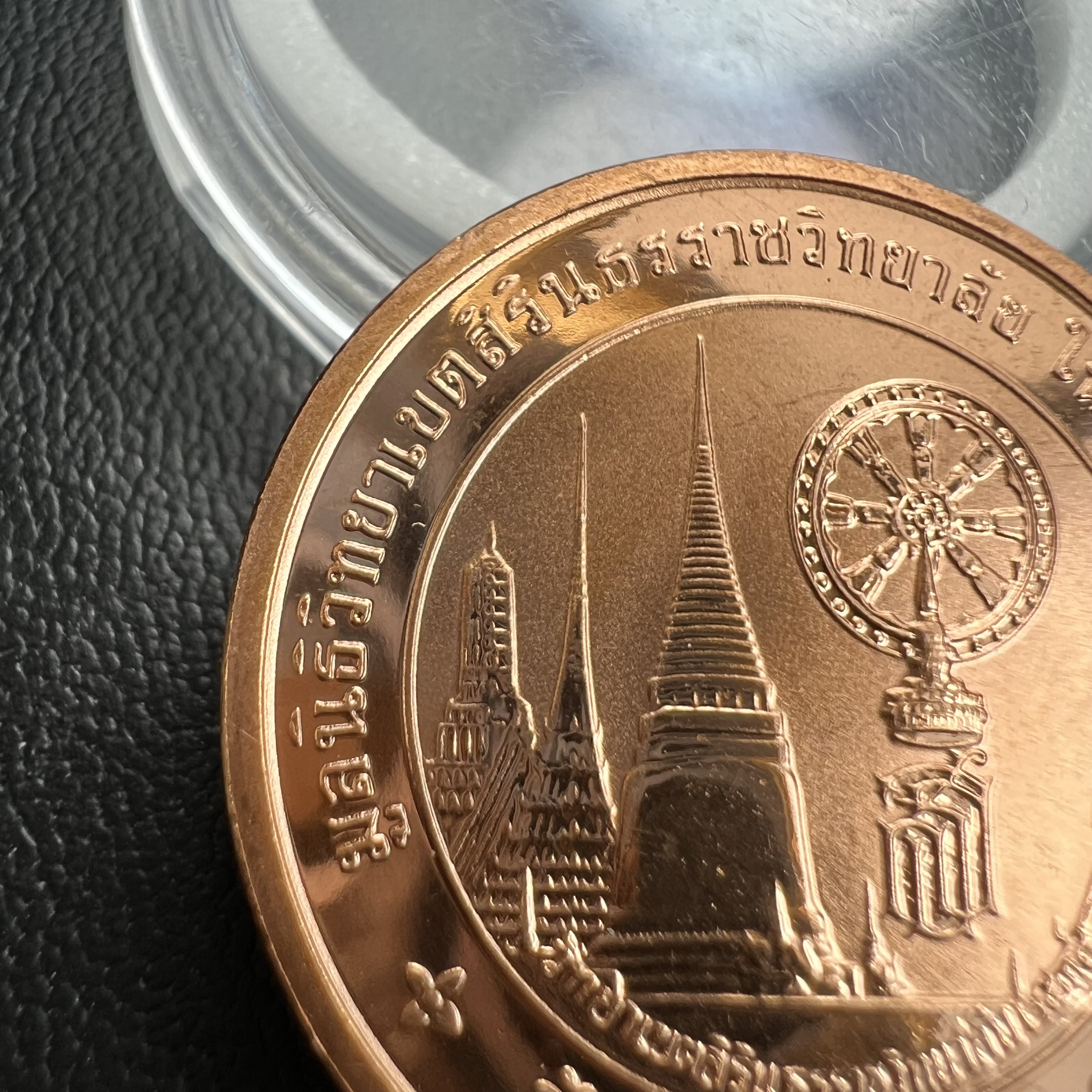 เหรียญพระแก้วมรกต ทรงเครื่องฤดูหนาว หลัง สธ.รุ่นเฉลิมพระเกียรติ ออกโดยมูลนิธิวิทยาเขตสิรินธรราชวิทยาลัย ในพระบรมราชูปถัมภ์ วัดบวรนิเวศวิหาร ปี 2538 เนื้อทองแดงบริสุทธิ์ 99.50% ขัดเงาสามมิติ ขนาด 2.7 ซม.ผลิตโดยโรงกษาปณ์ POB JOY MINT LTD.UK ประเทศอังกฤษ(เหร