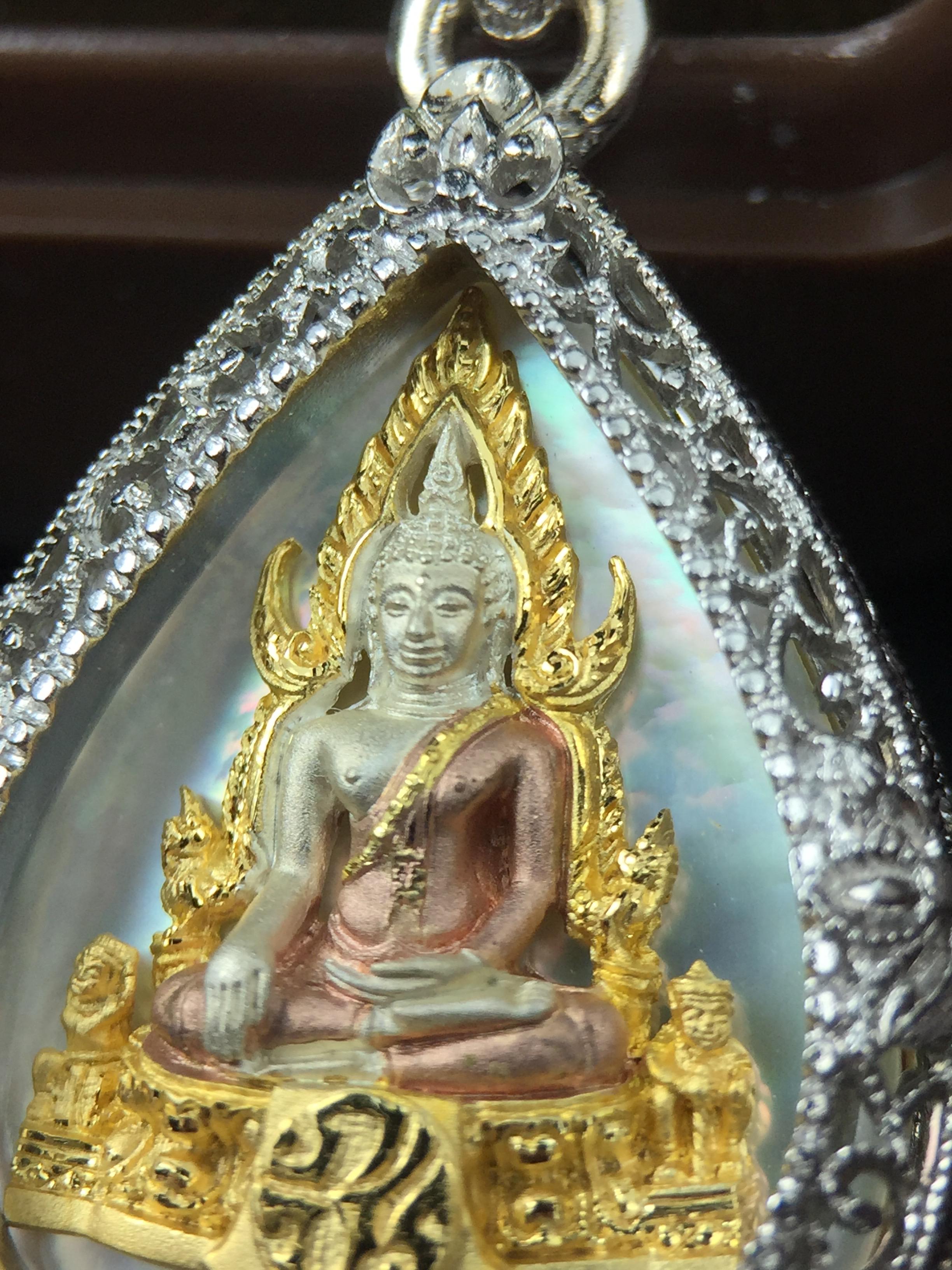 พระพุทธชินราช ภปร. โครงการ "เพราะแผ่นดินนี้ คือ แผ่นดินเกิด" ปี2548(รุ่นแรก) เหรียญทรงใบโพธิ์ ขนาด 21 x 29 มม. เนื้อเงินสามกษัตริย์ องค์พระชุบสามกษัตริย์ ล้อมด้วยกรอบเงินชุบทองคำขาวสลักเสลาเป็นลวดลายละเอียดอ่อน ส่วนพื้นองค์พระเป็นเปลือกหอยมุข