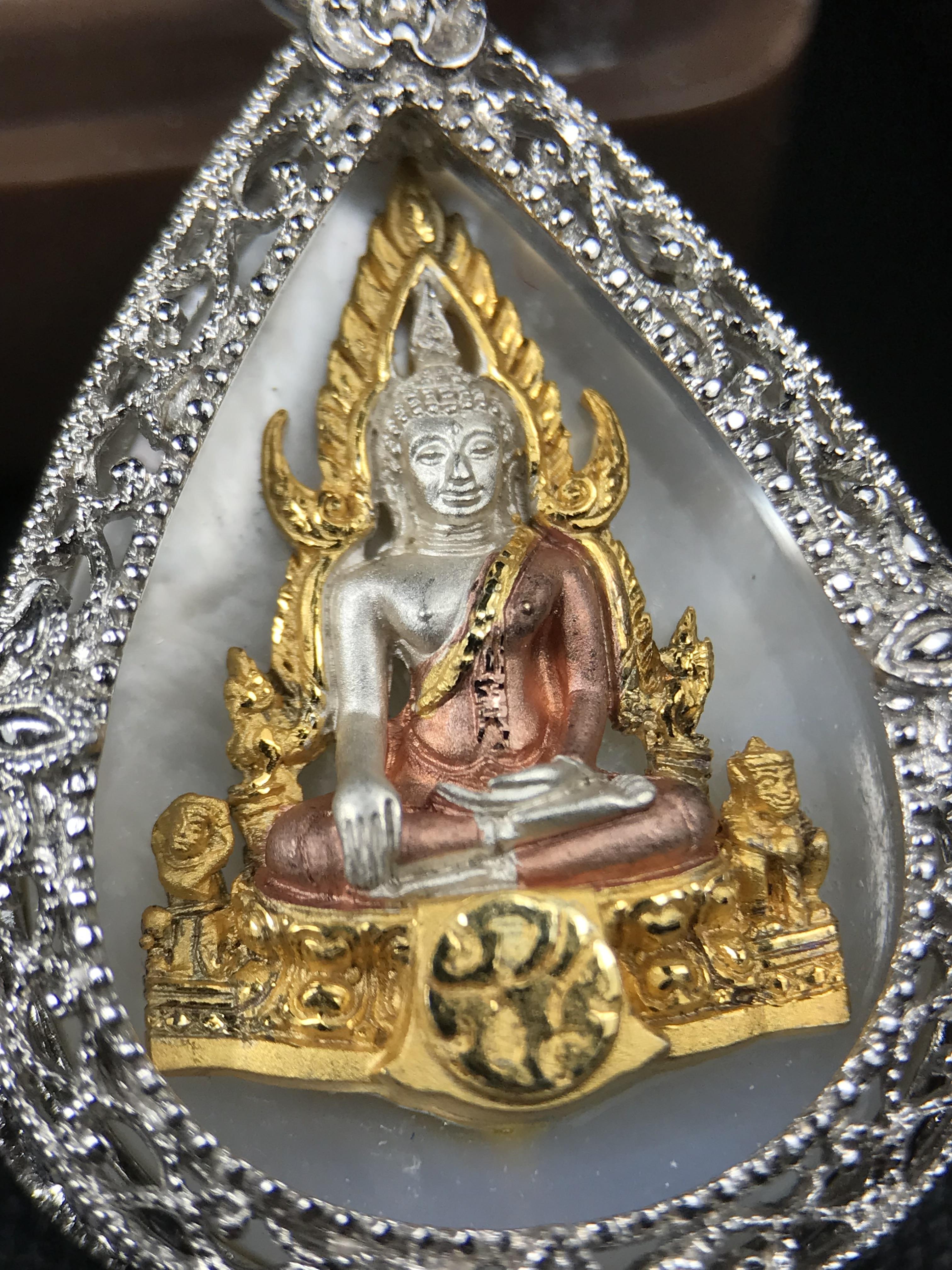 พระพุทธชินราช ภปร. โครงการ "เพราะแผ่นดินนี้ คือ แผ่นดินเกิด" ปี 2548(รุ่นแรก) เหรียญทรงหยดน้ำ ขนาด 21 x 31 มม. เนื้อเงินสามกษัตริย์ องค์พระชุบสามกษัตริย์ ล้อมด้วยกรอบเงินชุบทองคำขาวสลักเสลาเป็นลวดลายละเอียดอ่อน ส่วนพื้นองค์พระเป็นเปลือกหอยมุข