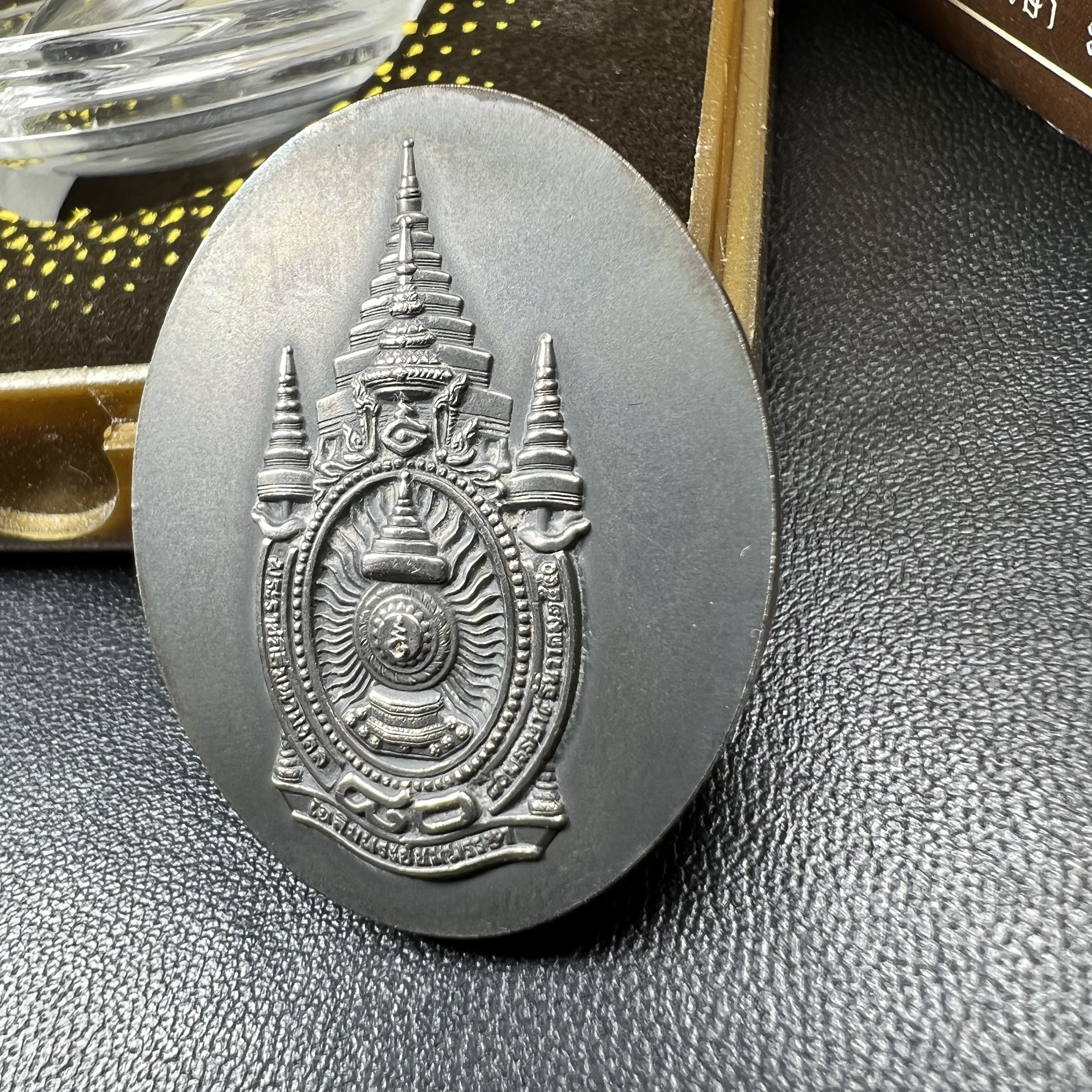 เหรียญรูปหล่อพระบาทสมเด็จพระเจ้าอยู่หัว ในหลวงทรงงาน “รุ่นเย็นศิระเพราะพระบริบาล 80พรรษา มหากษัตริย์คู่แผ่นดินสยาม” พ.ศ.2550 เนื้อเงินรมดำ(ขนาด 27*35 มม.) พร้อมกล่องบรรจุเดิมครบ