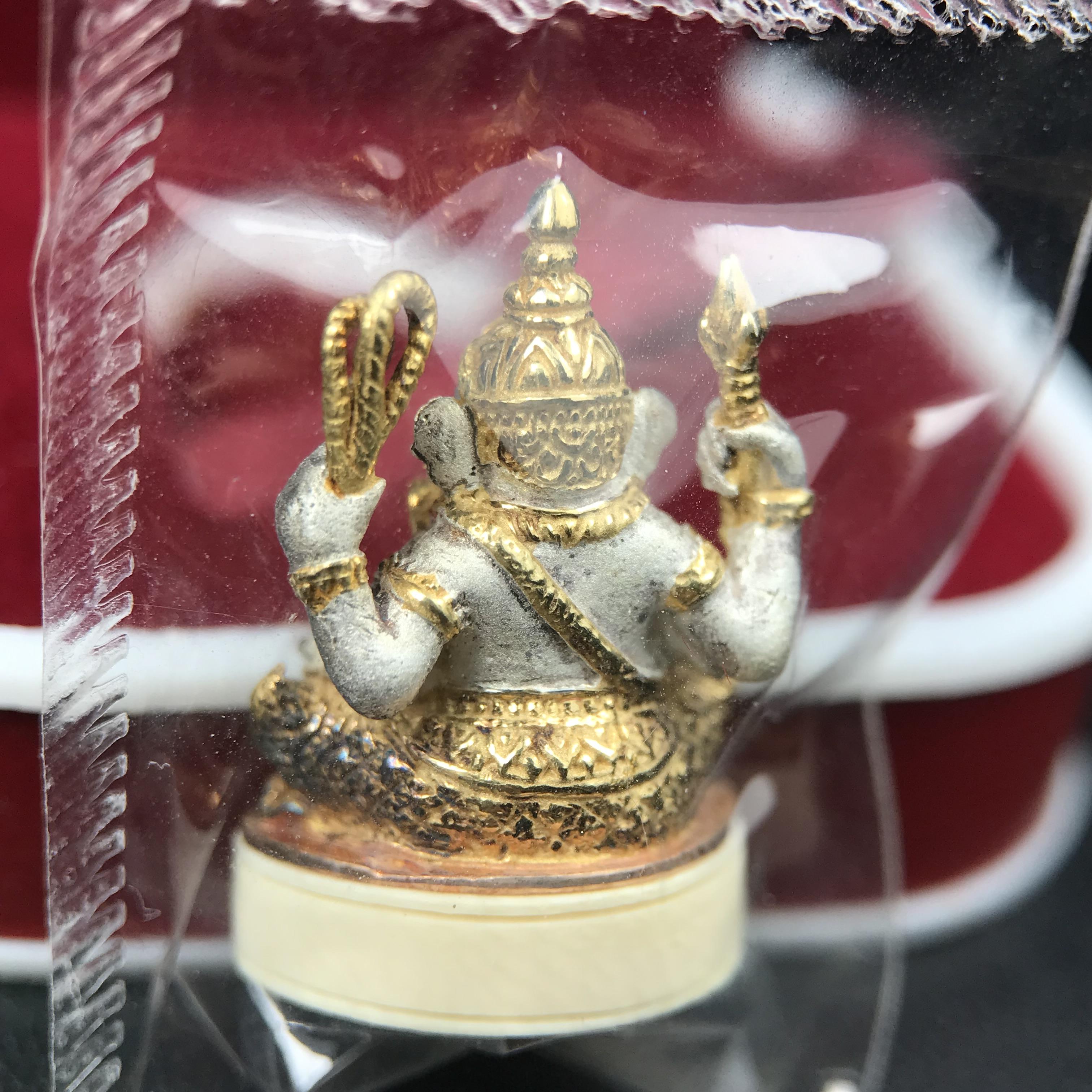 พระพิฆเนศวร รุ่น คชสารหมื่นปี รูปเหมือนพระพิฆเนศวรนั่งประทานพรฐานงาช้างแมมมอสขนาดห้อยคอ เนื้อเงินชุบสามกษัตริย์ขัดเงา พิมพ์เล็ก สูง 2.2 ซม. ฝังพลอยทับทิมแท้ พิธีมหาเทวาภิเษก ณ. เทวสถานโบสถ์พราหมณ์ (เสาชิงช้า) โดยเกจิคณาจารย์ทั่วประทศ ปี 2545(หมายเลข ๓๐)