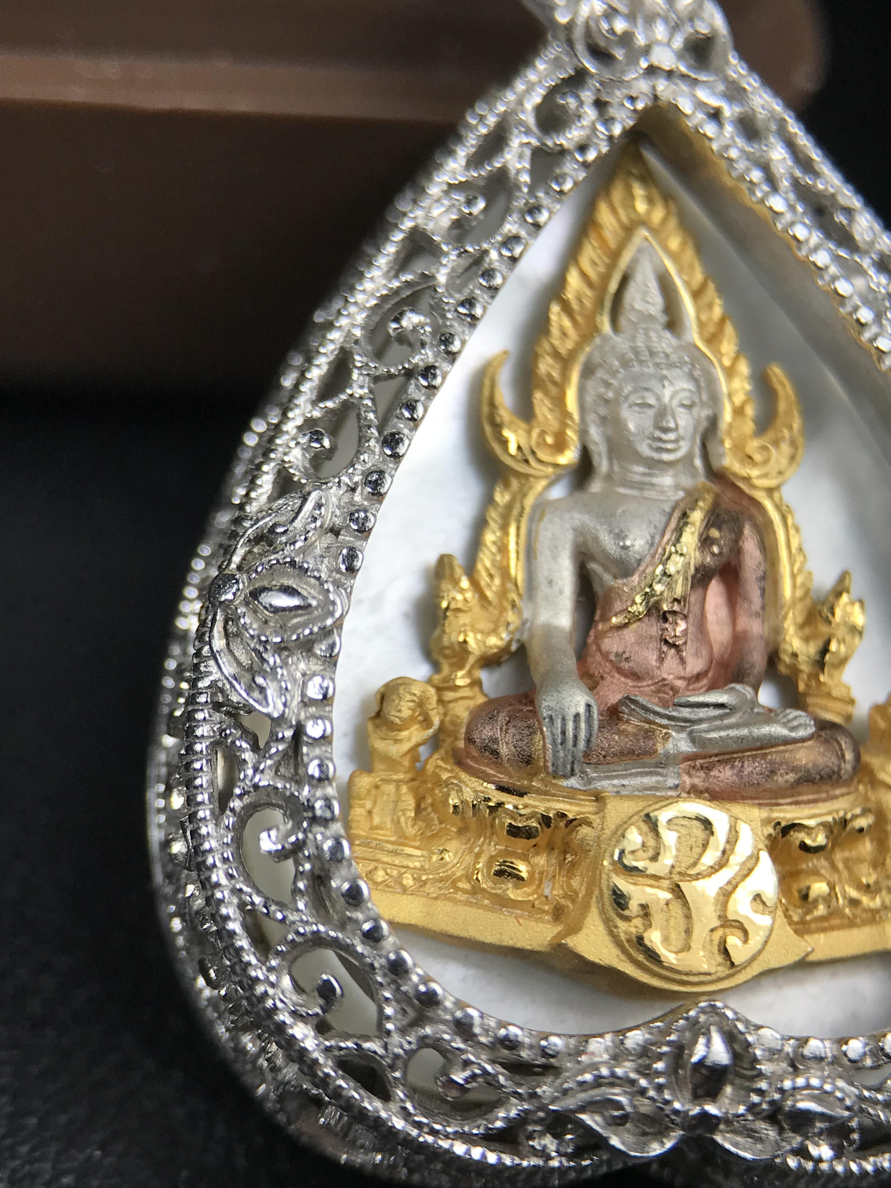 พระพุทธชินราช ภปร. โครงการ "เพราะแผ่นดินนี้ คือ แผ่นดินเกิด" ปี 2548(รุ่นแรก) เหรียญทรงใบโพธิ์ ขนาด 21 x 29 มม. เนื้อเงินสามกษัตริย์ องค์พระชุบสามกษัตริย์ ล้อมด้วยกรอบเงินชุบทองคำขาวสลักเสลาเป็นลวดลายละเอียดอ่อน ส่วนพื้นองค์พระเป็นเปลือกหอยมุข