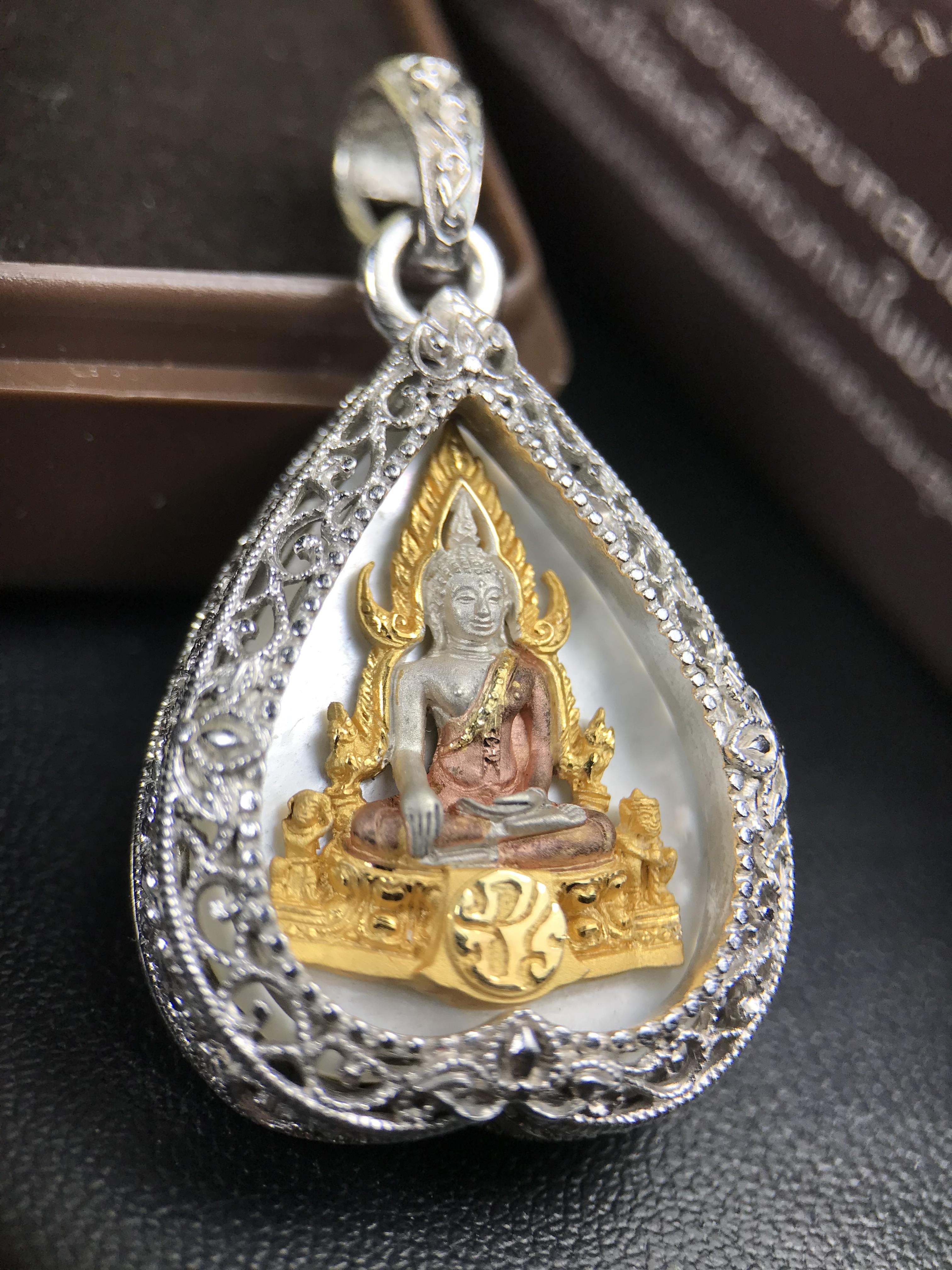 พระพุทธชินราช ภปร. โครงการ "เพราะแผ่นดินนี้ คือ แผ่นดินเกิด" ปี 2548(รุ่นแรก) เหรียญทรงใบโพธิ์ ขนาด 21 x 29 มม. เนื้อเงินสามกษัตริย์ องค์พระชุบสามกษัตริย์ ล้อมด้วยกรอบเงินชุบทองคำขาวสลักเสลาเป็นลวดลายละเอียดอ่อน ส่วนพื้นองค์พระเป็นเปลือกหอยมุข