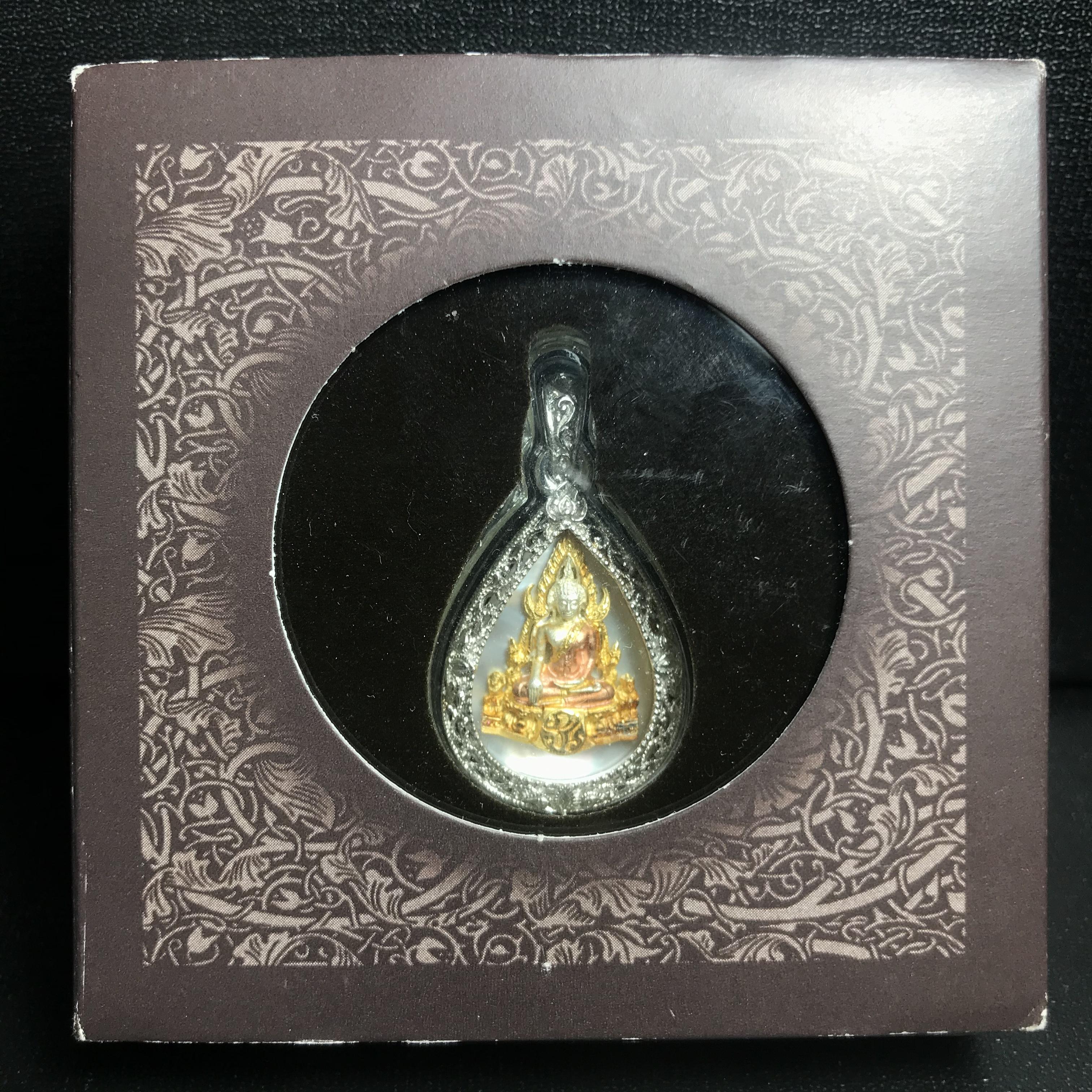 พระพุทธชินราช ภปร. โครงการ "เพราะแผ่นดินนี้ คือ แผ่นดินเกิด" ปี2548(รุ่นแรก) เหรียญทรงหยดน้ำ ขนาด 21 x 31 มม. เนื้อเงินสามกษัตริย์ องค์พระชุบสามกษัตริย์ ล้อมด้วยกรอบเงินชุบทองคำขาวสลักเสลาเป็นลวดลายละเอียดอ่อน ส่วนพื้นองค์พระเป็นเปลือกหอยมุข