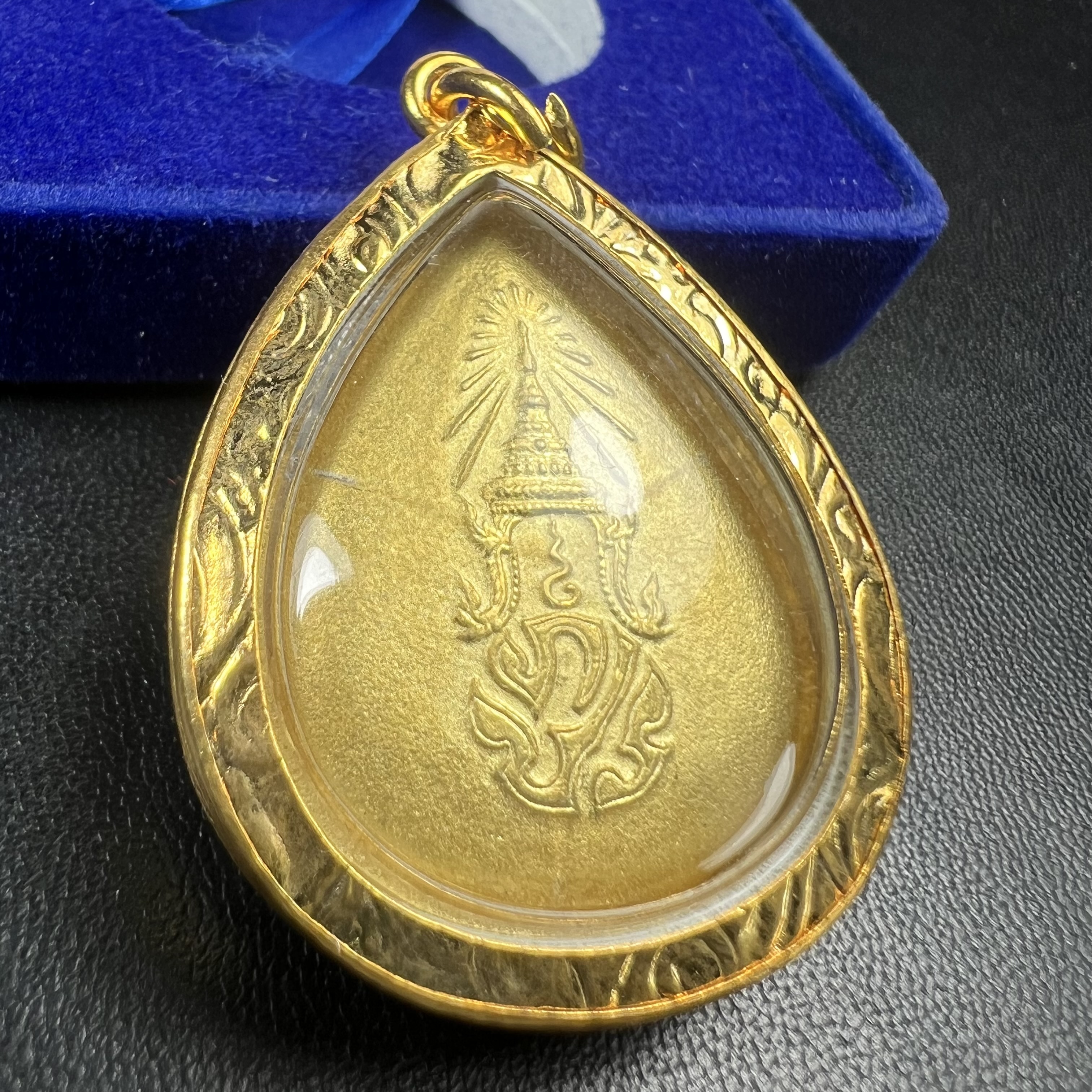 เหรียญพระพุทธสิงหธรรมมงคล ภปร. ปี 2547 ทรงหยดน้ำ ด้านหลังมี ภ.ป.ร. (ชนวนเก่า)เนื้อโลหะผสม ชุบทองพ่นทราย สูง 3.3ซม.พิธีใหญ่ มวลสารดี ปลุกเสกวัดพระแก้ว(งานเลี่ยมกรอบเดิมจากผู้จัดสร้างห่อหุ้มด้วยทองนพเกล้า)