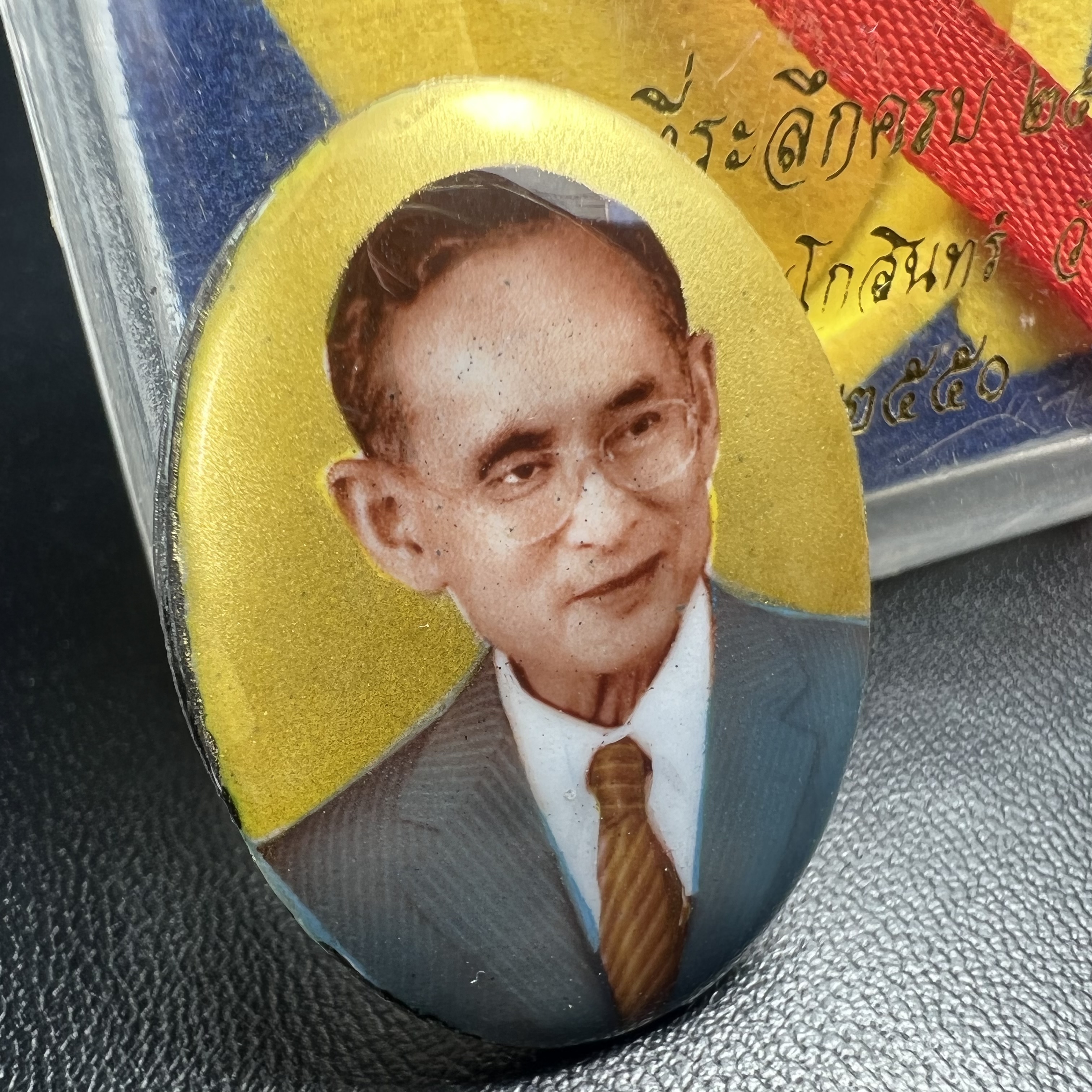 ล็อกเกตในหลวงรัชกาลที่9 ที่ระลึกครบ 25 ปี มูลนิธิศรีรัตนโกสินทร์ วัดสุทธาราม พ.ศ. 2550 พิมพ์ทรงวงรีรูปไข่เล็กฉากสีทอง หลังปิดแผ่นโลหะสีขาว(สแตนเลส)ฝังพระยอดธง(นิยม)