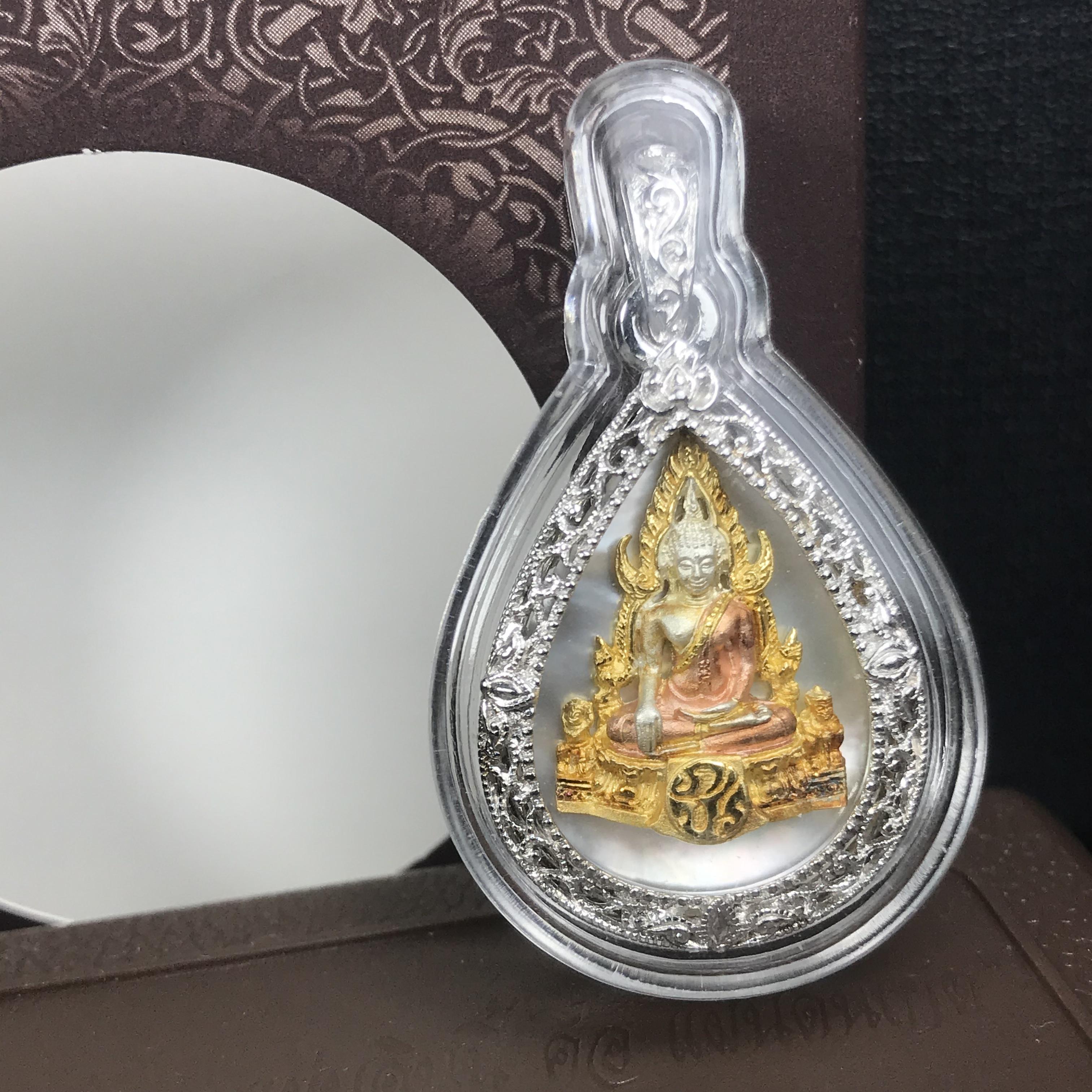 พระพุทธชินราช ภปร. โครงการ "เพราะแผ่นดินนี้ คือ แผ่นดินเกิด" ปี2548(รุ่นแรก) เหรียญทรงหยดน้ำ ขนาด 21 x 31 มม. เนื้อเงินสามกษัตริย์ องค์พระชุบสามกษัตริย์ ล้อมด้วยกรอบเงินชุบทองคำขาวสลักเสลาเป็นลวดลายละเอียดอ่อน ส่วนพื้นองค์พระเป็นเปลือกหอยมุข