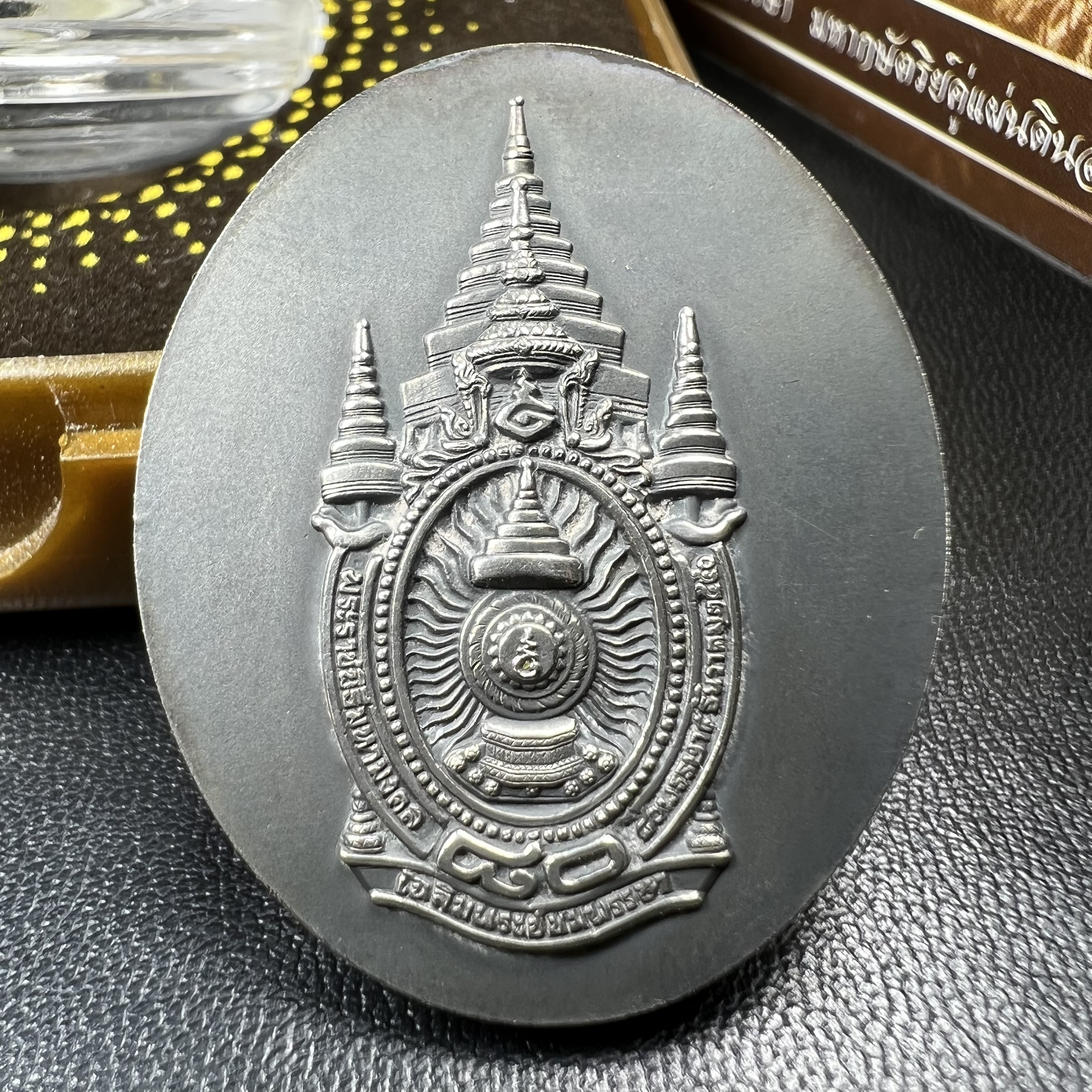 เหรียญรูปหล่อพระบาทสมเด็จพระเจ้าอยู่หัว ในหลวงทรงงาน “รุ่นเย็นศิระเพราะพระบริบาล 80พรรษา มหากษัตริย์คู่แผ่นดินสยาม” พ.ศ.2550 เนื้อเงินรมดำ(ขนาด 27*35 มม.) พร้อมกล่องบรรจุเดิมครบ