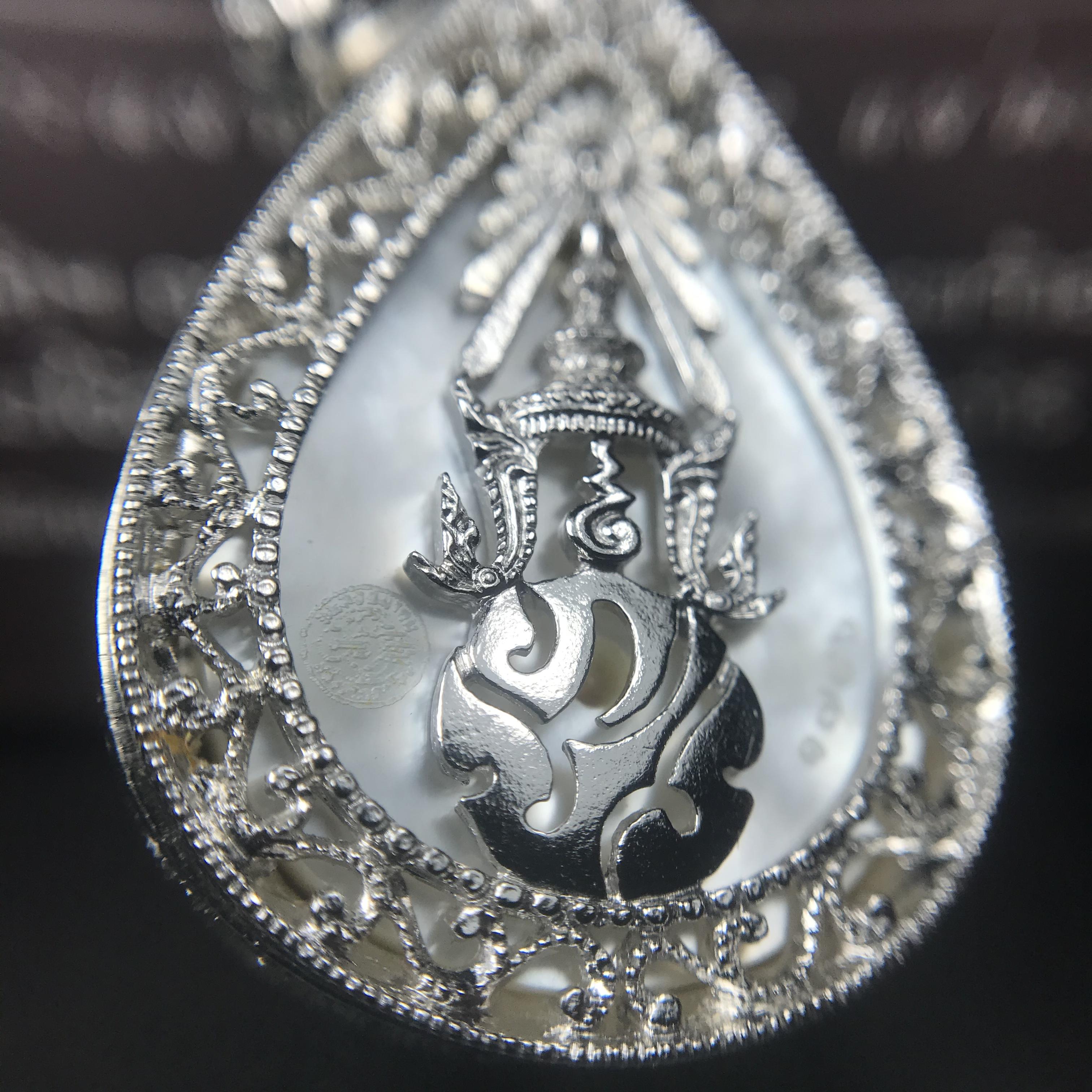 พระพุทธชินราช ภปร. โครงการ "เพราะแผ่นดินนี้ คือ แผ่นดินเกิด" ปี2548(รุ่นแรก) เหรียญทรงหยดน้ำ ขนาด 21 x 31 มม. เนื้อเงินสามกษัตริย์ องค์พระชุบสามกษัตริย์ ล้อมด้วยกรอบเงินชุบทองคำขาวสลักเสลาเป็นลวดลายละเอียดอ่อน ส่วนพื้นองค์พระเป็นเปลือกหอยมุข