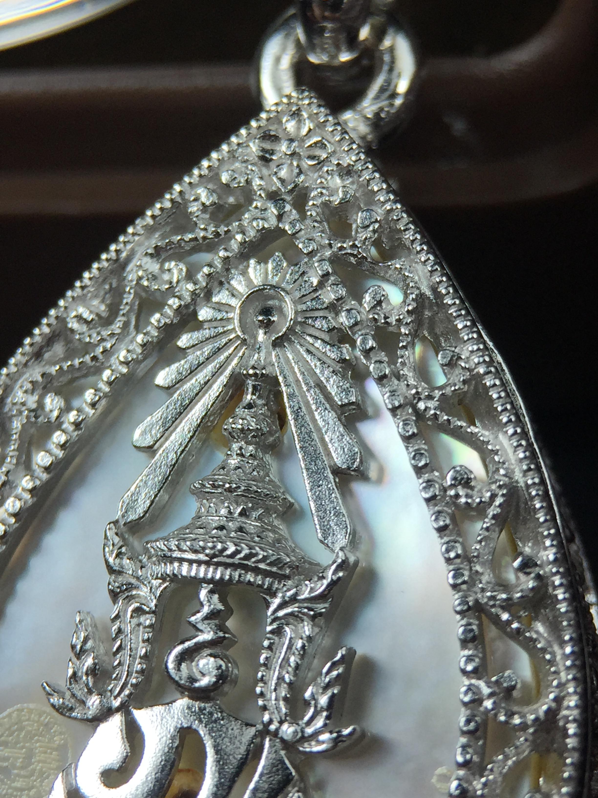 พระพุทธชินราช ภปร. โครงการ "เพราะแผ่นดินนี้ คือ แผ่นดินเกิด" ปี2548(รุ่นแรก) เหรียญทรงหยดน้ำ ขนาด 21 x 31 มม. เนื้อเงินสามกษัตริย์ องค์พระชุบสามกษัตริย์ ล้อมด้วยกรอบเงินชุบทองคำขาวสลักเสลาเป็นลวดลายละเอียดอ่อน ส่วนพื้นองค์พระเป็นเปลือกหอยมุข