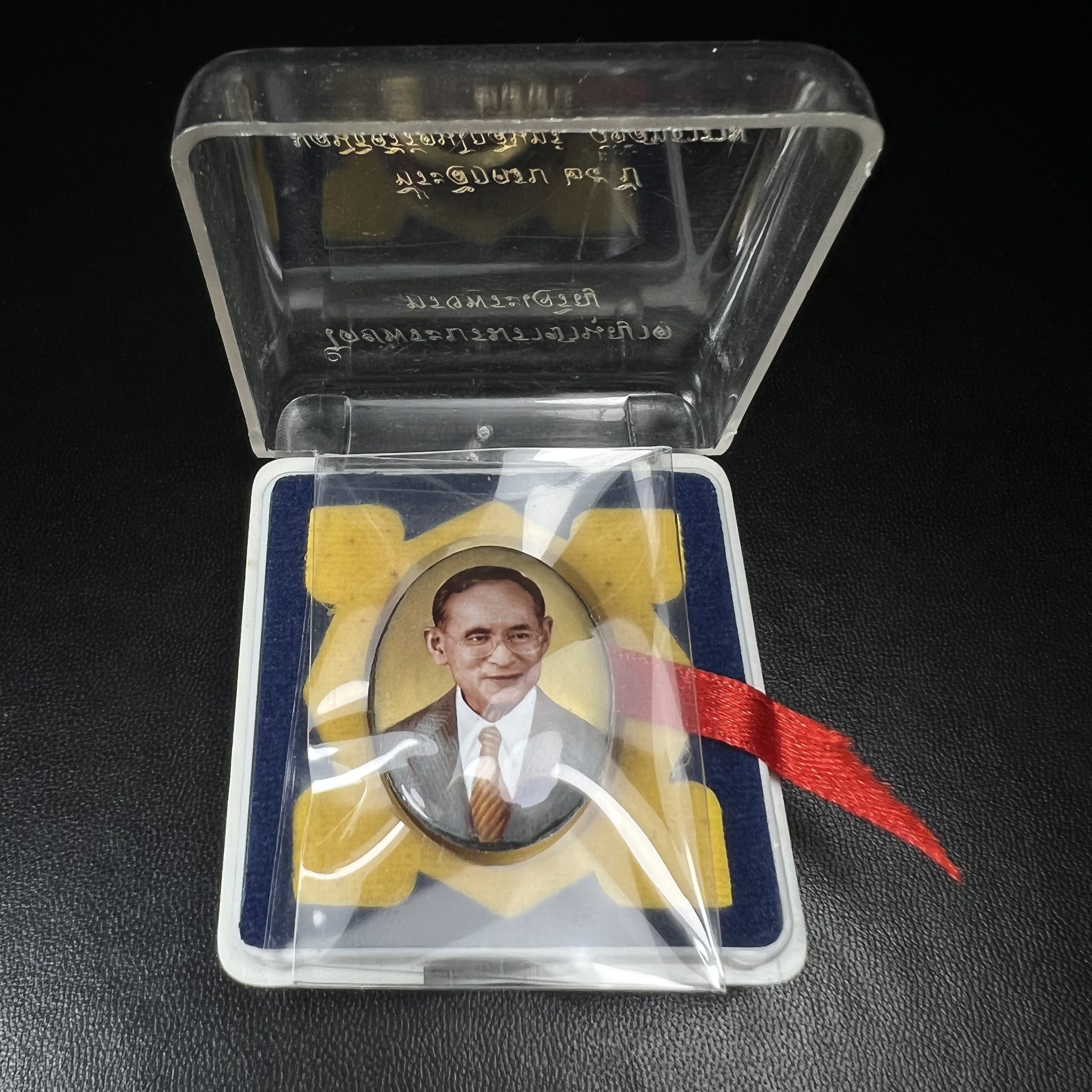 ล็อกเกตในหลวงรัชกาลที่9 ที่ระลึกครบ 25 ปี มูลนิธิศรีรัตนโกสินทร์ วัดสุทธาราม พ.ศ. 2550 พิมพ์ทรงวงรีรูปไข่เล็กฉากสีทอง หลังปิดแผ่นโลหะสีขาว(สแตนเลส)ฝังพระยอดธง(นิยม)