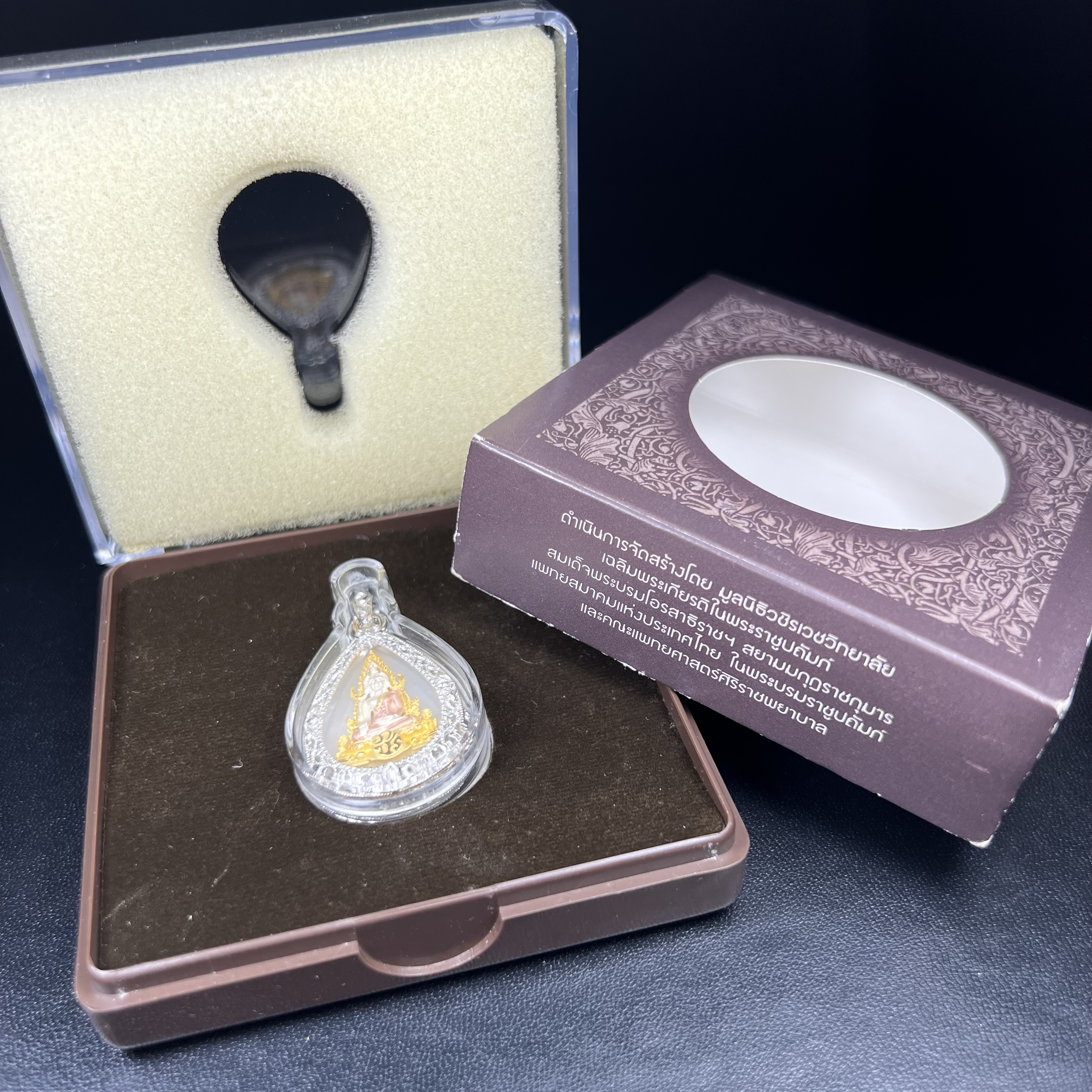 พระพุทธชินราช ภปร. โครงการ "เพราะแผ่นดินนี้ คือ แผ่นดินเกิด" ปี2548(รุ่นแรก) เหรียญทรงหยดน้ำ ขนาด 21 x 31 มม. เนื้อเงินสามกษัตริย์ องค์พระชุบสามกษัตริย์ ล้อมด้วยกรอบเงินชุบทองคำขาวสลักเสลาเป็นลวดลายละเอียดอ่อน ส่วนพื้นองค์พระเป็นเปลือกหอยมุข