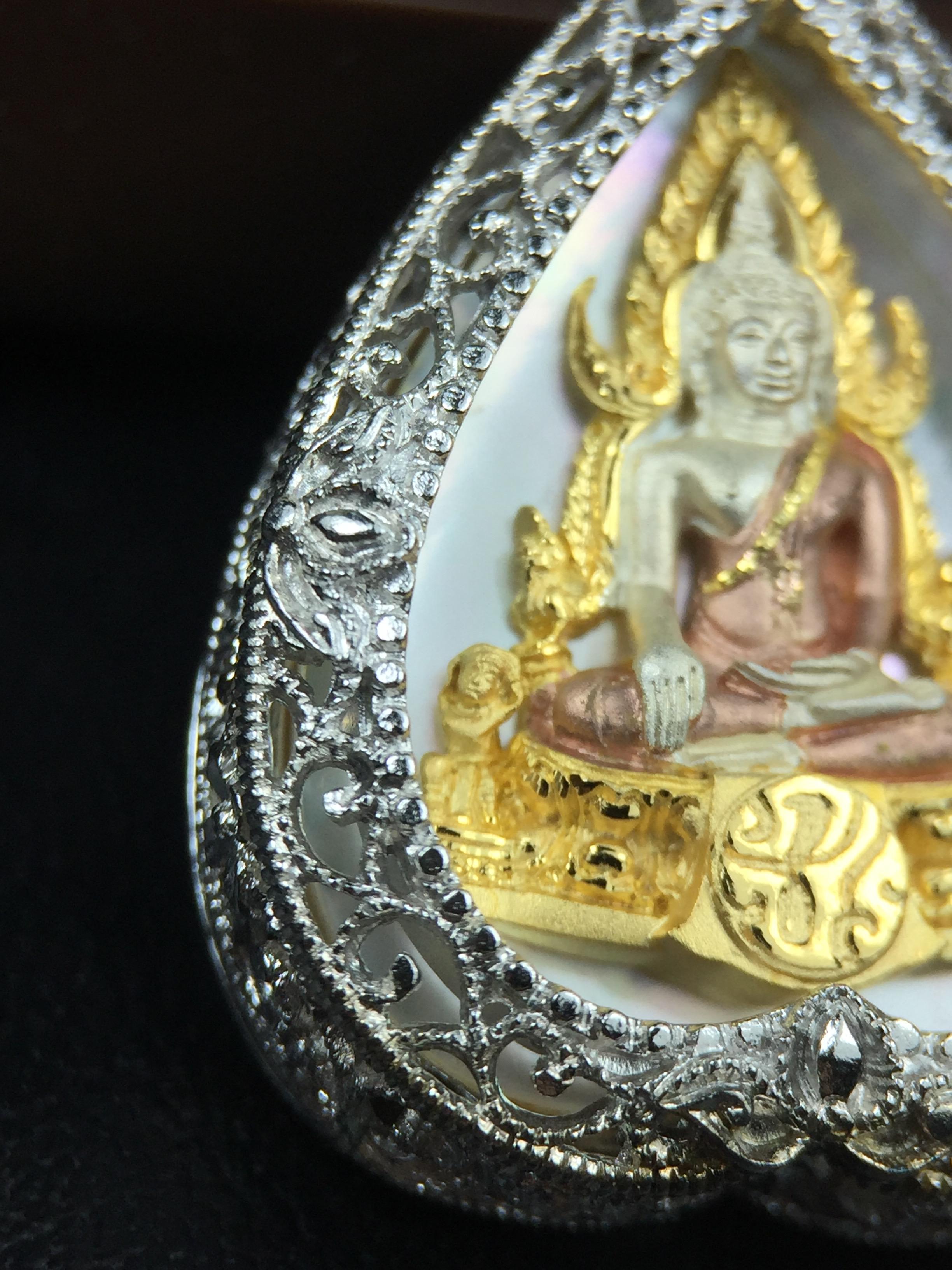 พระพุทธชินราช ภปร. โครงการ "เพราะแผ่นดินนี้ คือ แผ่นดินเกิด" ปี2548(รุ่นแรก) เหรียญทรงใบโพธิ์ ขนาด 21 x 29 มม. เนื้อเงินสามกษัตริย์ องค์พระชุบสามกษัตริย์ ล้อมด้วยกรอบเงินชุบทองคำขาวสลักเสลาเป็นลวดลายละเอียดอ่อน ส่วนพื้นองค์พระเป็นเปลือกหอยมุข