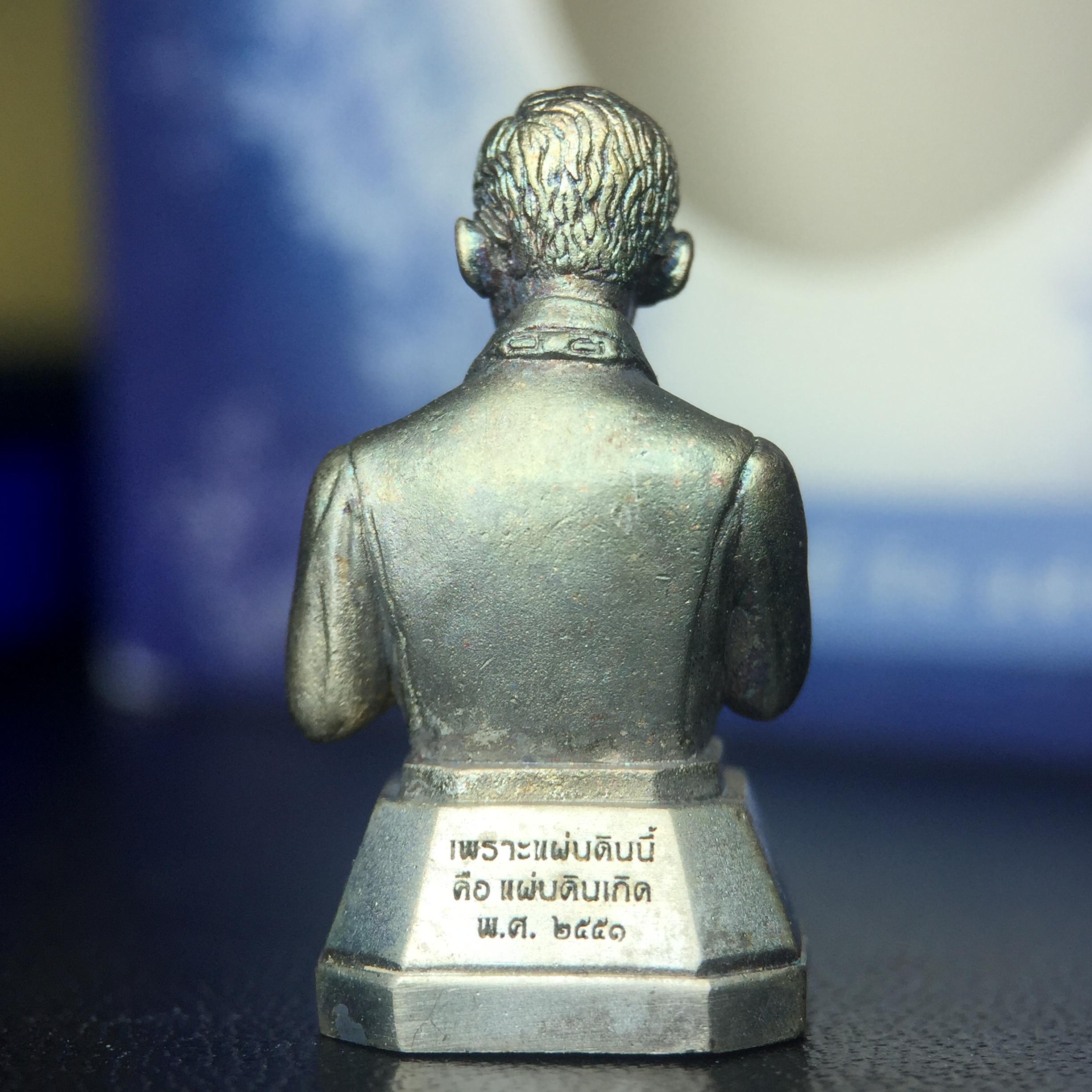 พระบรมรูปพระบาทสมเด็จพระเจ้าอยู่หัวรัชกาลที่ 9(ทรงงาน) ภปร. รุ่นเพราะแผ่นดินนี้คือแผ่นดินเกิด ปี 2551 ขนาดสูง 1 นิ้ว เนื้อเงิน(ผิวเดิมขึ้นสีรุ้งธรรมชาติสวยมาก)(ด้านหน้า ฐานพระบรมรูปฯ ประดิษฐานอักษรพระปรมาภิไธย ภ.ป.ร.)นิยมหายาก(1 ใน 5000 องค์)