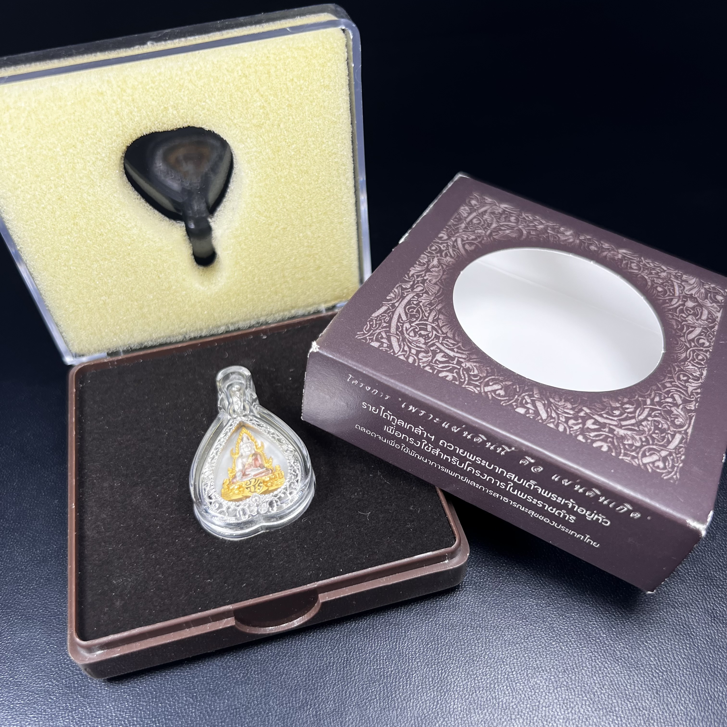 พระพุทธชินราช ภปร. โครงการ "เพราะแผ่นดินนี้ คือ แผ่นดินเกิด" ปี 2548(รุ่นแรก) เหรียญทรงใบโพธิ์ ขนาด 21 x 29 มม. เนื้อเงินสามกษัตริย์ องค์พระชุบสามกษัตริย์ ล้อมด้วยกรอบเงินชุบทองคำขาวสลักเสลาเป็นลวดลายละเอียดอ่อน ส่วนพื้นองค์พระเป็นเปลือกหอยมุข