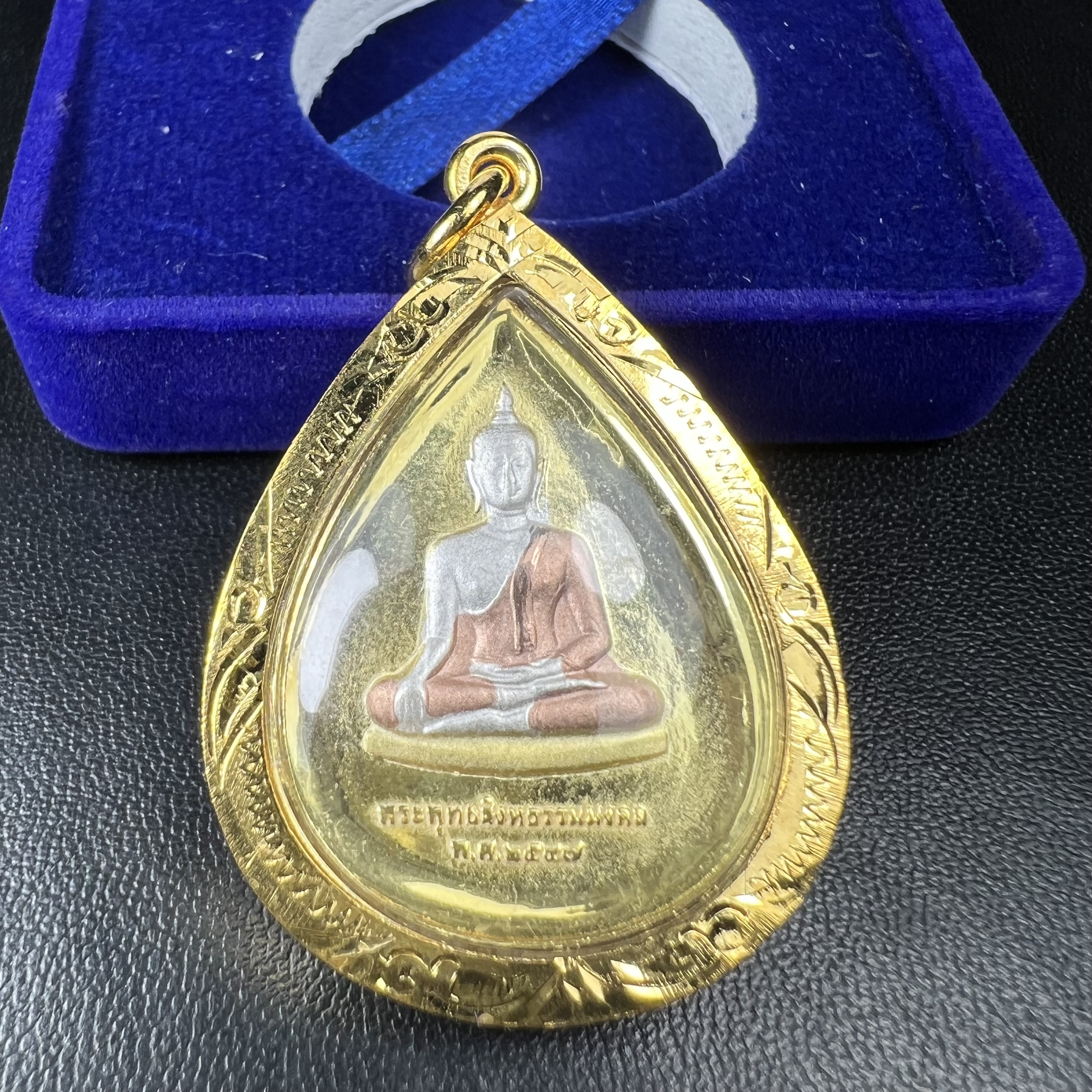 เหรียญพระพุทธสิงหธรรมมงคล ภปร. ปี 2547 ทรงหยดน้ำ ด้านหลังมี ภ.ป.ร. (ชนวนเก่า)เนื้อโลหะผสม ชุบทองสามกษัตริย์ สูง 3.3ซม.พิธีใหญ่ มวลสารดี ปลุกเสกวัดพระแก้ว(งานเลี่ยมกรอบเดิมจากผู้จัดสร้างห่อหุ้มด้วยทองนพเกล้า)