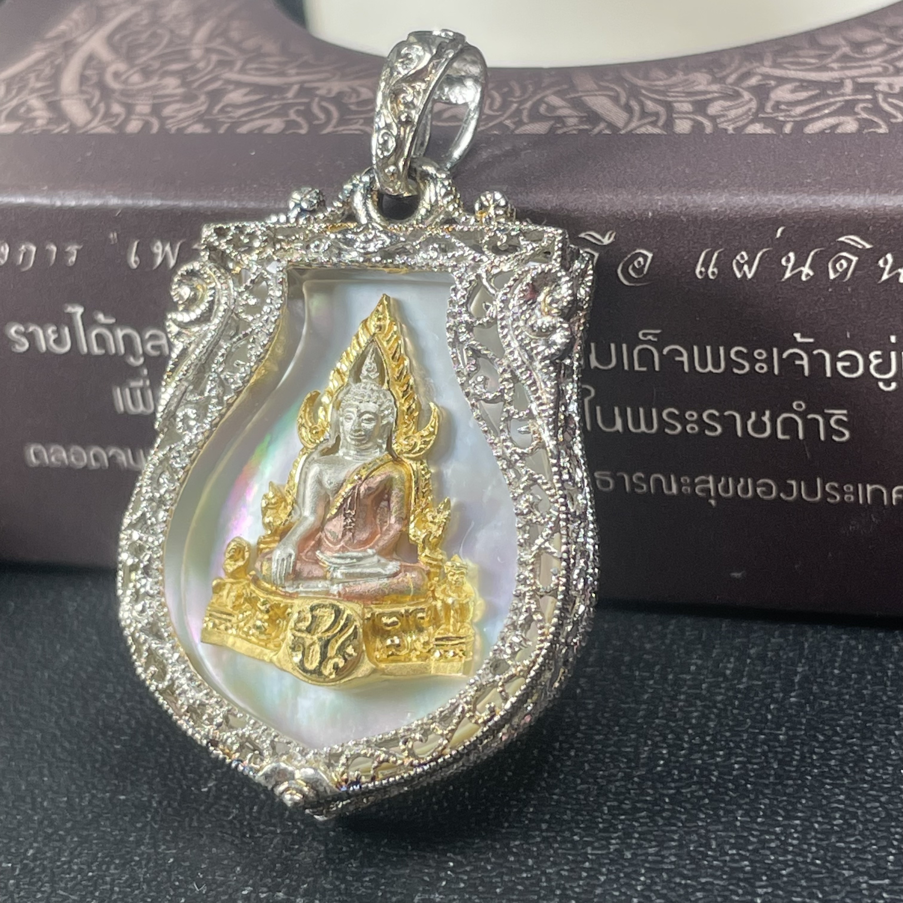 พระพุทธชินราช ภปร. โครงการ "เพราะแผ่นดินนี้ คือ แผ่นดินเกิด" ปี2548(รุ่นแรก) เหรียญทรงเสมา ขนาด 21 x 29 มม.เนื้อเงินสามกษัตริย์ องค์พระชุบสามกษัตริย์ ล้อมด้วยกรอบเงินชุบทองคำขาวสลักเสลาเป็นลวดลายละเอียดอ่อน ส่วนพื้นองค์พระเป็นเปลือกหอยมุขงดงาม