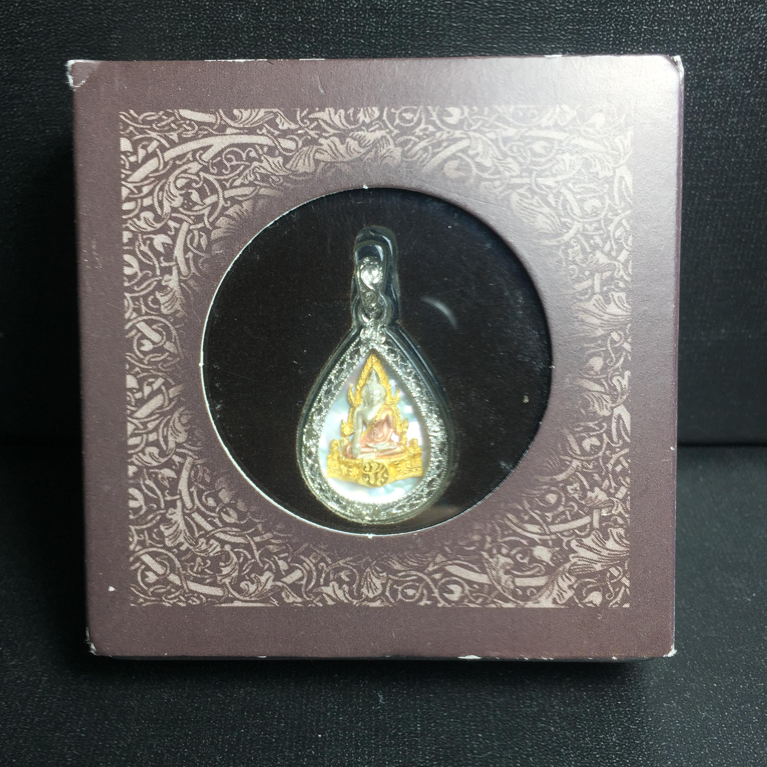 พระพุทธชินราช ภปร. โครงการ "เพราะแผ่นดินนี้ คือ แผ่นดินเกิด" ปี2548(รุ่นแรก) เหรียญทรงหยดน้ำ ขนาด 21 x 31 มม. เนื้อเงินสามกษัตริย์ องค์พระชุบสามกษัตริย์ ล้อมด้วยกรอบเงินชุบทองคำขาวสลักเสลาเป็นลวดลายละเอียดอ่อน ส่วนพื้นองค์พระเป็นเปลือกหอยมุข