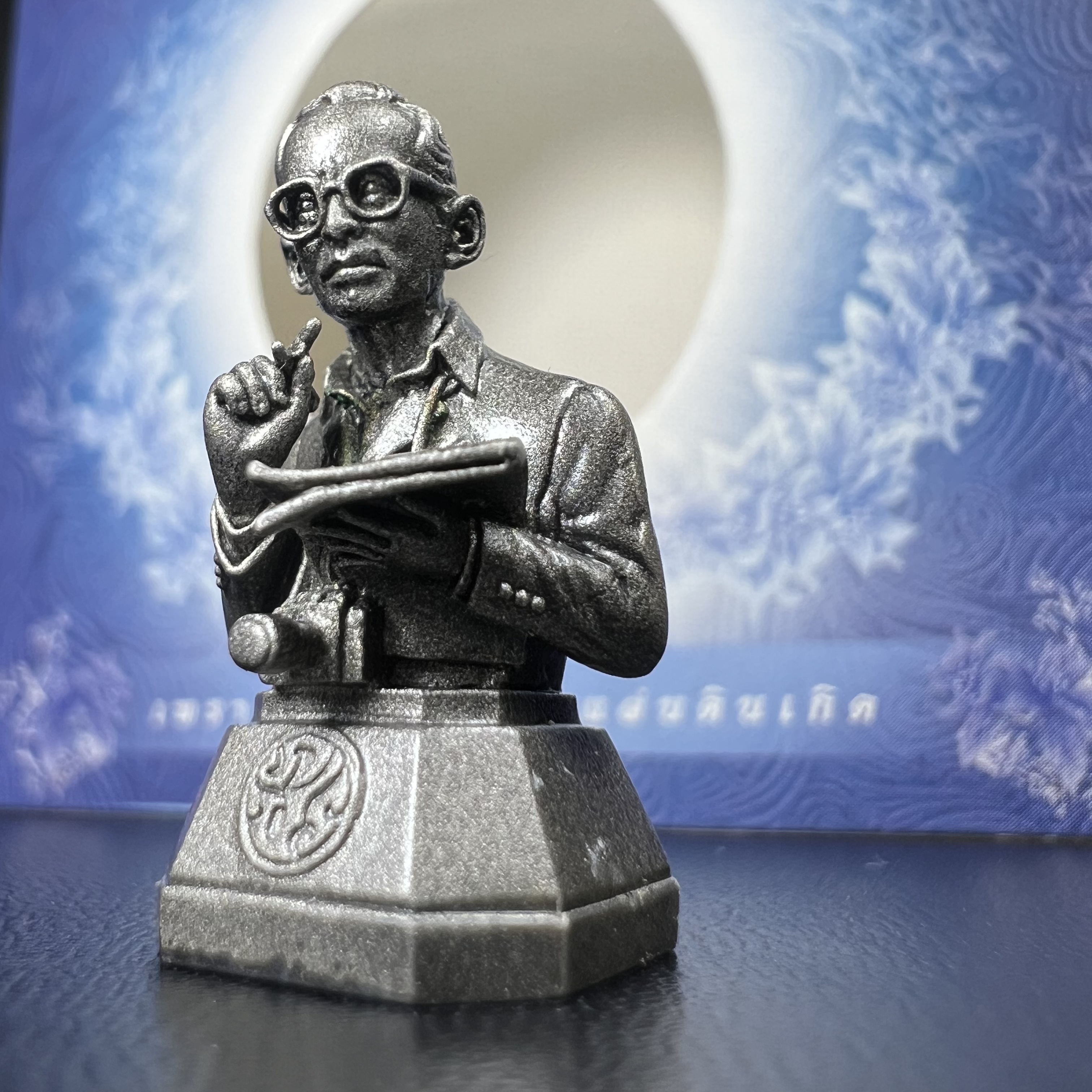 พระบรมรูปพระบาทสมเด็จพระเจ้าอยู่หัวรัชกาลที่ 9(ทรงงาน) ภปร. รุ่นเพราะแผ่นดินนี้คือแผ่นดินเกิด ปี 2551 ขนาดสูง 1 นิ้ว เนื้อบรอนซ์ชุบเงินรมดำ(ด้านหน้า ฐานพระบรมรูปฯ ประดิษฐานอักษรพระปรมาภิไธย ภ.ป.ร.)นิยมหายาก