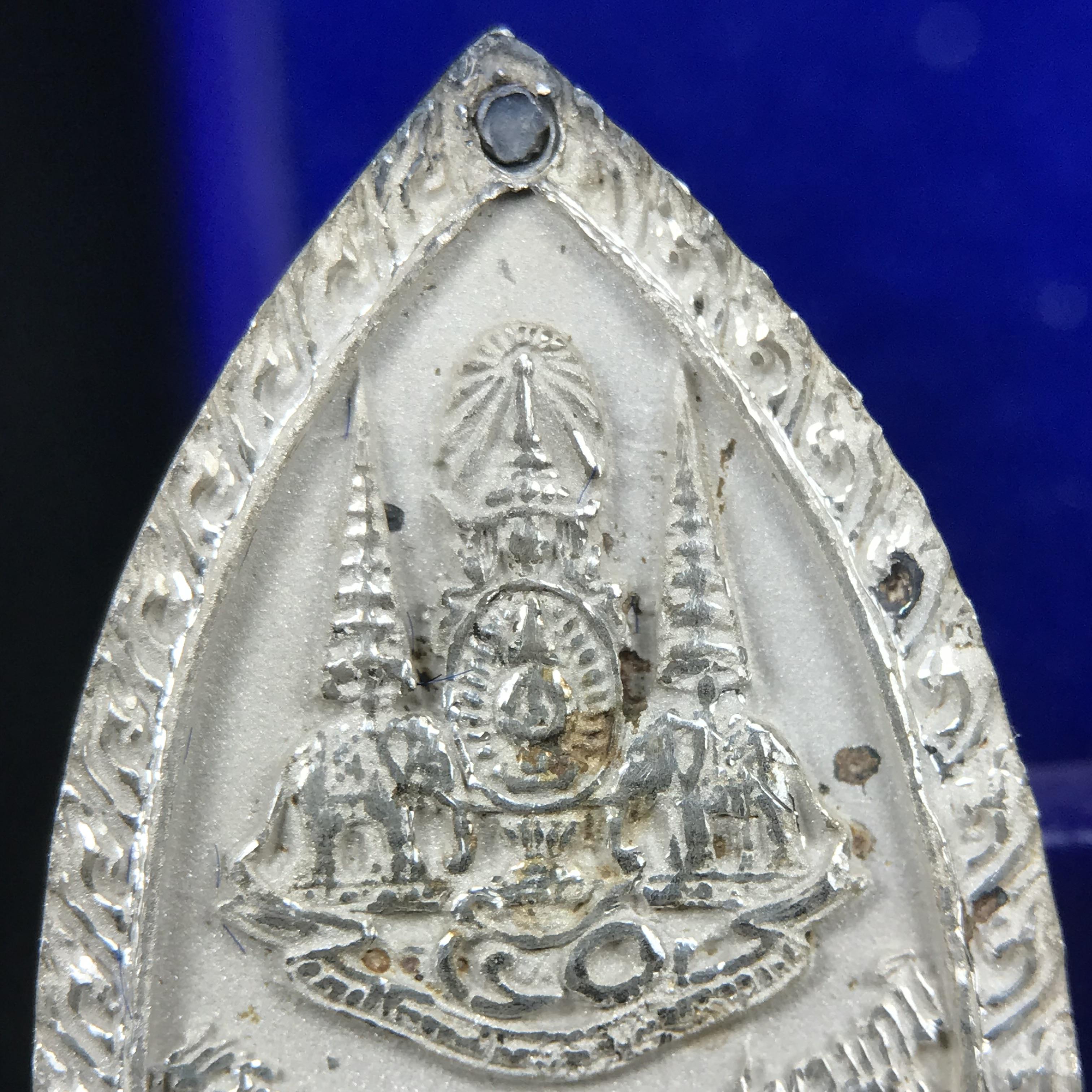 พระพุทธกาญจนพรสยามภูมิ ภปร. ปี 2539 เนื้อเงินพื้นทรายประกาย(ผิวเดิมสวย) พิมพ์ทรงใบขนุน ขนาด3.2ซม. พระพุทธรูปประจำพระชนมวาร รัชกาลที่9 ทรงโปรดเกล้าให้วิทยาลัยป้องกันราชอาณาจักร(วปอ.)สร้างในวโรกาสทรงครองสิริราชสมบัติครบ50ปี พ.ศ.2539(1ใน5000องค์)