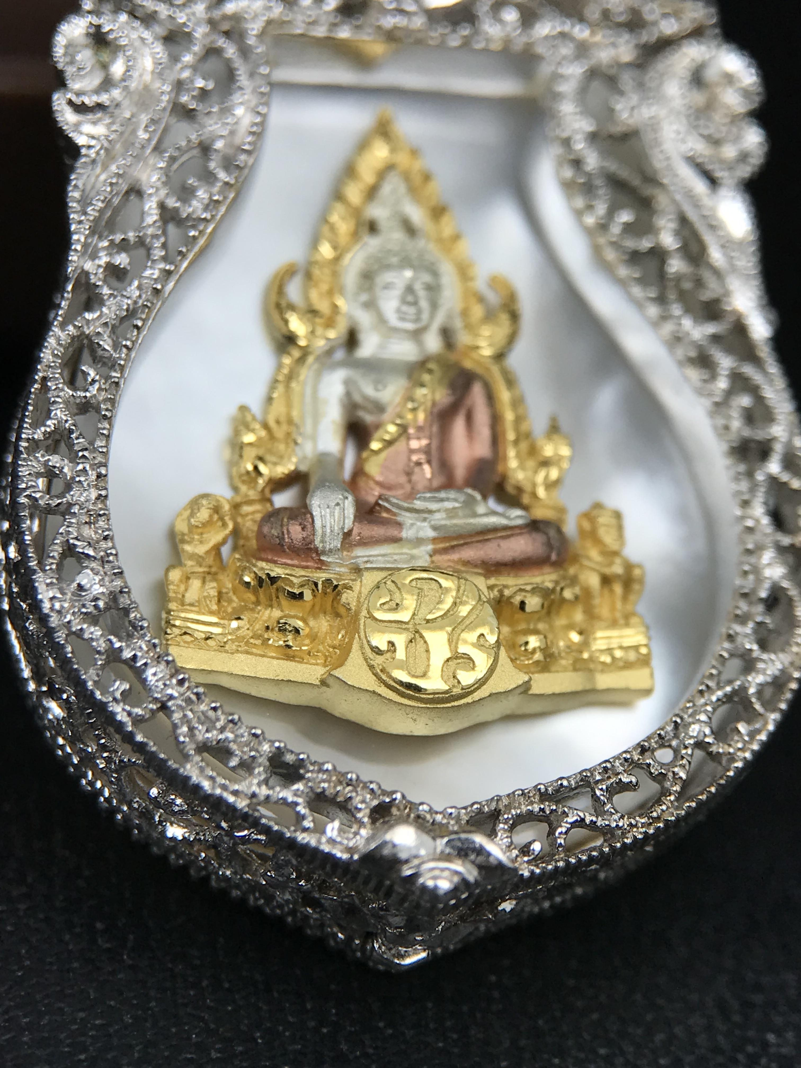 พระพุทธชินราช ภปร. โครงการ "เพราะแผ่นดินนี้ คือ แผ่นดินเกิด" ปี2548(รุ่นแรก) เหรียญทรงเสมา ขนาด 21 x 29 มม.เนื้อเงินสามกษัตริย์ องค์พระชุบสามกษัตริย์ ล้อมด้วยกรอบเงินชุบทองคำขาวสลักเสลาเป็นลวดลายละเอียดอ่อน ส่วนพื้นองค์พระเป็นเปลือกหอยมุขงดงาม