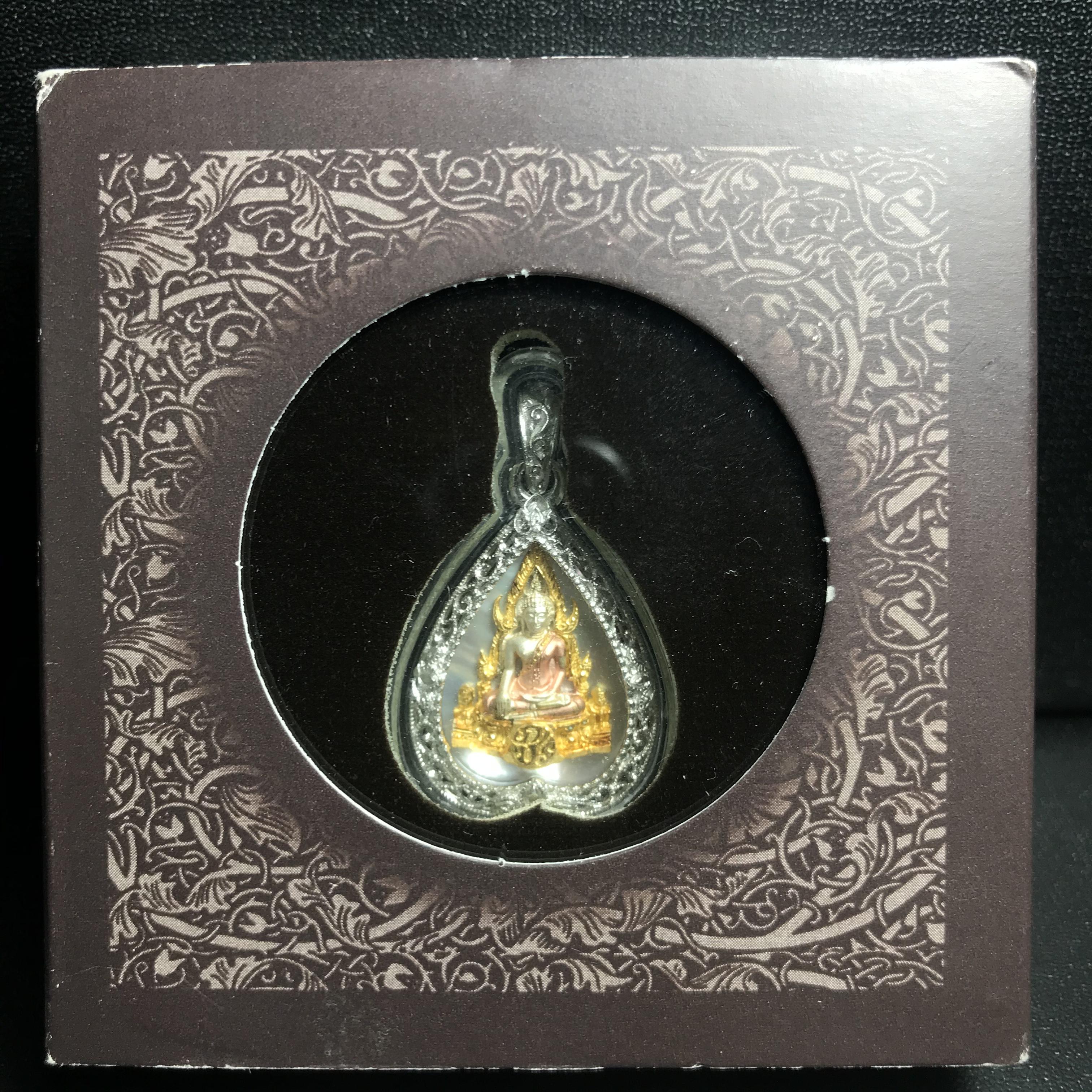 พระพุทธชินราช ภปร. โครงการ "เพราะแผ่นดินนี้ คือ แผ่นดินเกิด" ปี2548(รุ่นแรก) เหรียญทรงใบโพธิ์ ขนาด 21 x 29 มม. เนื้อเงินสามกษัตริย์ องค์พระชุบสามกษัตริย์ ล้อมด้วยกรอบเงินชุบทองคำขาวสลักเสลาเป็นลวดลายละเอียดอ่อน ส่วนพื้นองค์พระเป็นเปลือกหอยมุข