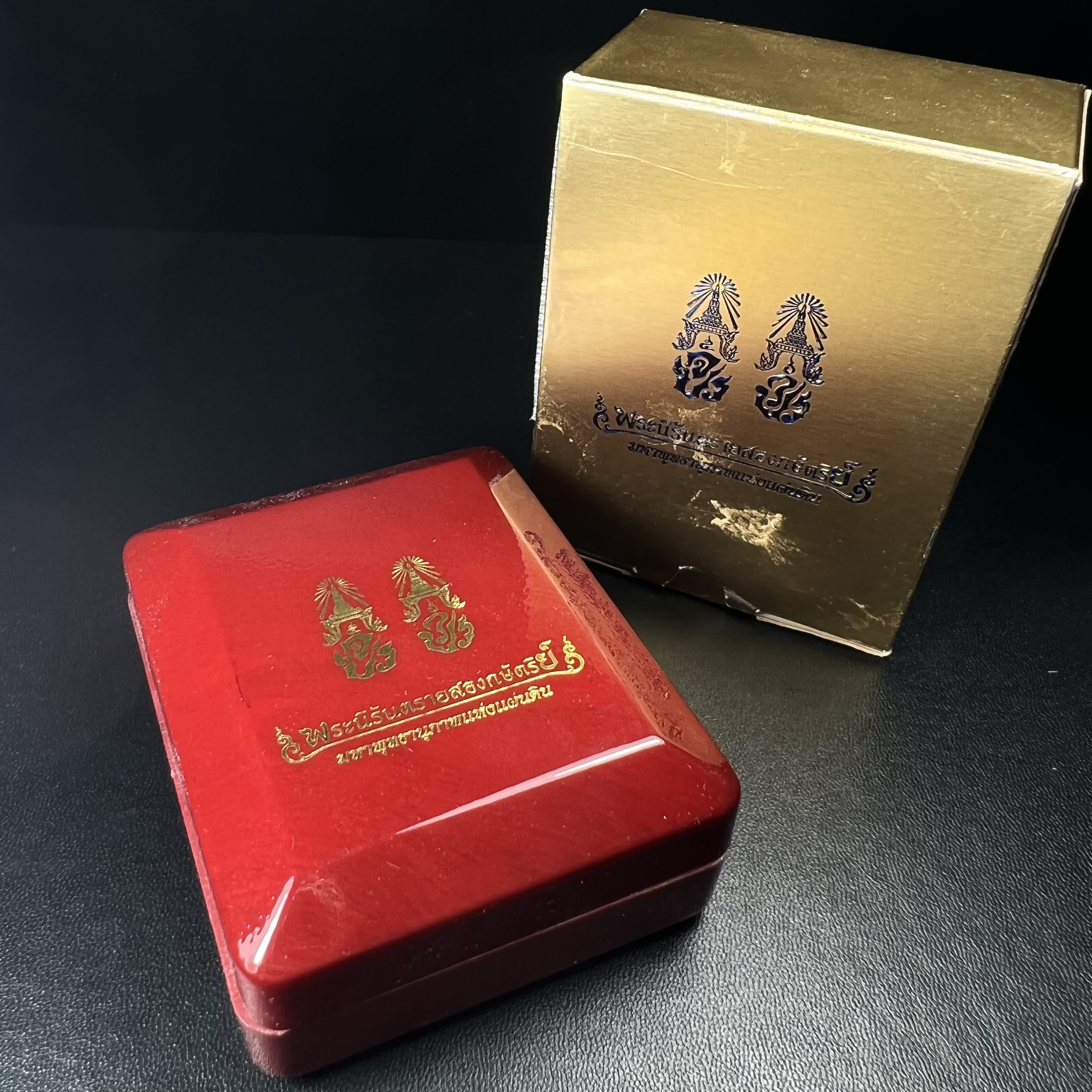 พระนิรันตรายสองกษัตริย์ มหาพุทธานุภาพแห่งแผ่นดิน ปี2552 "พระผู้ปกป้องคุ้มครองจากภัยอันตรายทั้งปวง" พระผงพิมพ์สมเด็จหน้าปัดทอง สีดำด้านหลังฝังนวโลหะชุบนาก เชิญอักษรพระปรมาภิไธยสองกษัตริย์(จปร.และ วปร.) พร้อมกล่องบรรจุเดิมครบชุด