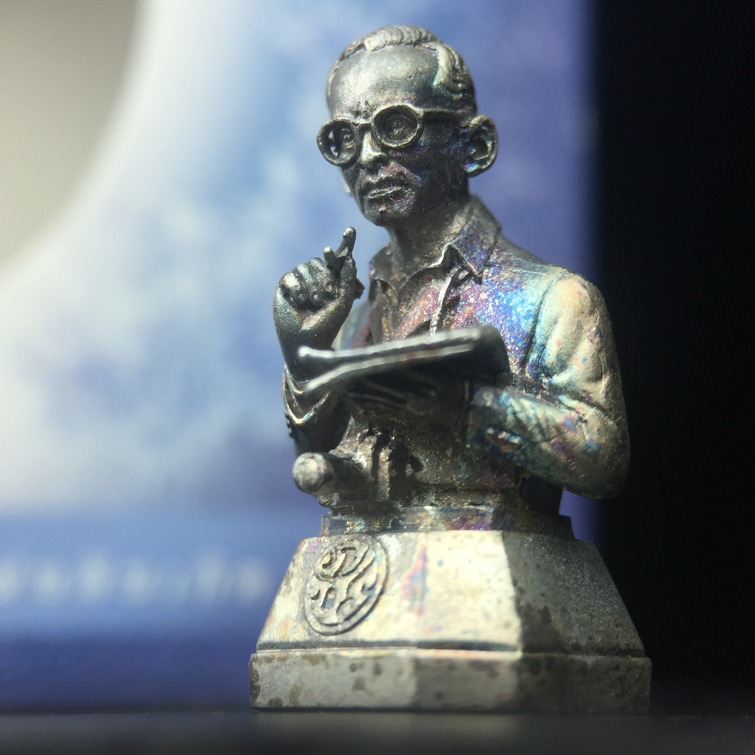 พระบรมรูปพระบาทสมเด็จพระเจ้าอยู่หัวรัชกาลที่ 9(ทรงงาน) ภปร. รุ่นเพราะแผ่นดินนี้คือแผ่นดินเกิด ปี 2551 ขนาดสูง 1 นิ้ว เนื้อเงิน(ผิวเดิมขึ้นสีรุ้งธรรมชาติสวยมาก)(ด้านหน้า ฐานพระบรมรูปฯ ประดิษฐานอักษรพระปรมาภิไธย ภ.ป.ร.)นิยมหายาก(1 ใน 5000 องค์)