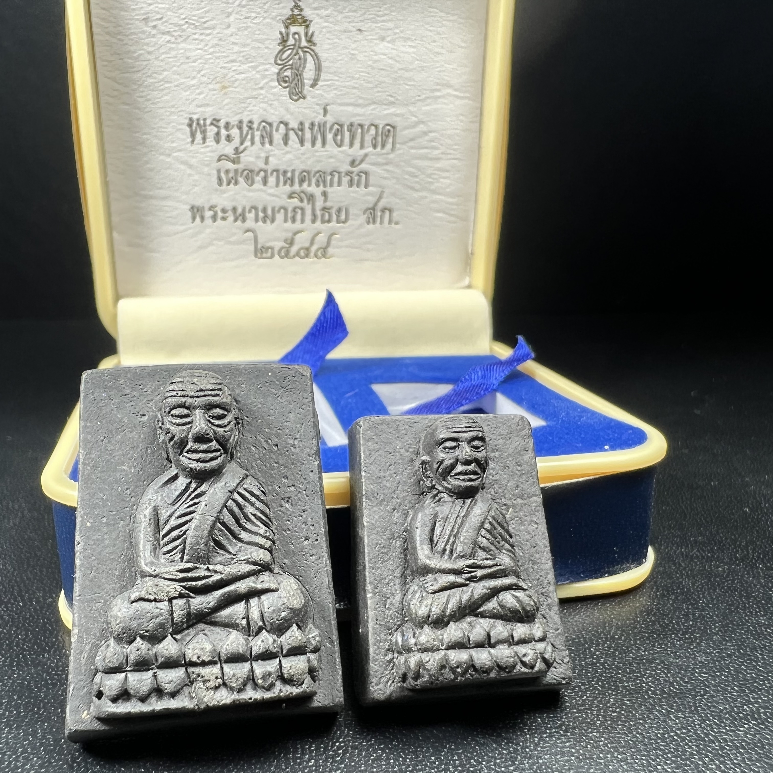 พระหลวงพ่อทวด พระนามาภิไธย สก. ปี2544(รุ่นแรก) เนื้อว่านคลุกรัก พิมพ์พิเศษหลังฝังข้าวสารดำ ชุดหลังพระนามาภิไธย สก. เนื้อเงิน(1ชุด 2องค์ พิมพ์ใหญ่สี่เหลี่ยม+พิมพ์เล็กพระรอดสี่เหลี่ยม)(1ใน5000 ชุด)พร้อมกล่องบรรจุเดิมหายาก