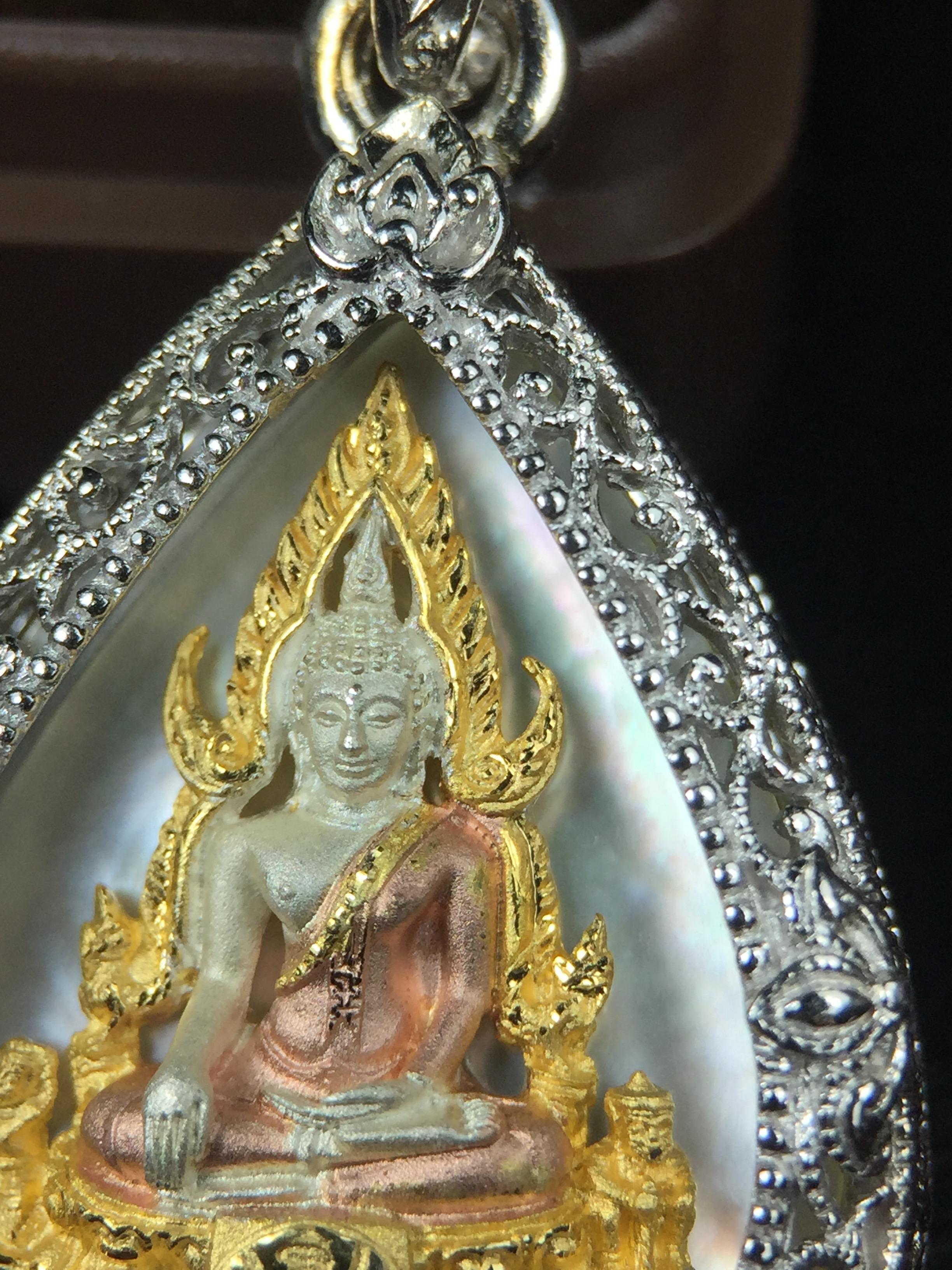 พระพุทธชินราช ภปร. โครงการ "เพราะแผ่นดินนี้ คือ แผ่นดินเกิด" ปี2548(รุ่นแรก) เหรียญทรงหยดน้ำ ขนาด 21 x 31 มม. เนื้อเงินสามกษัตริย์ องค์พระชุบสามกษัตริย์ ล้อมด้วยกรอบเงินชุบทองคำขาวสลักเสลาเป็นลวดลายละเอียดอ่อน ส่วนพื้นองค์พระเป็นเปลือกหอยมุข