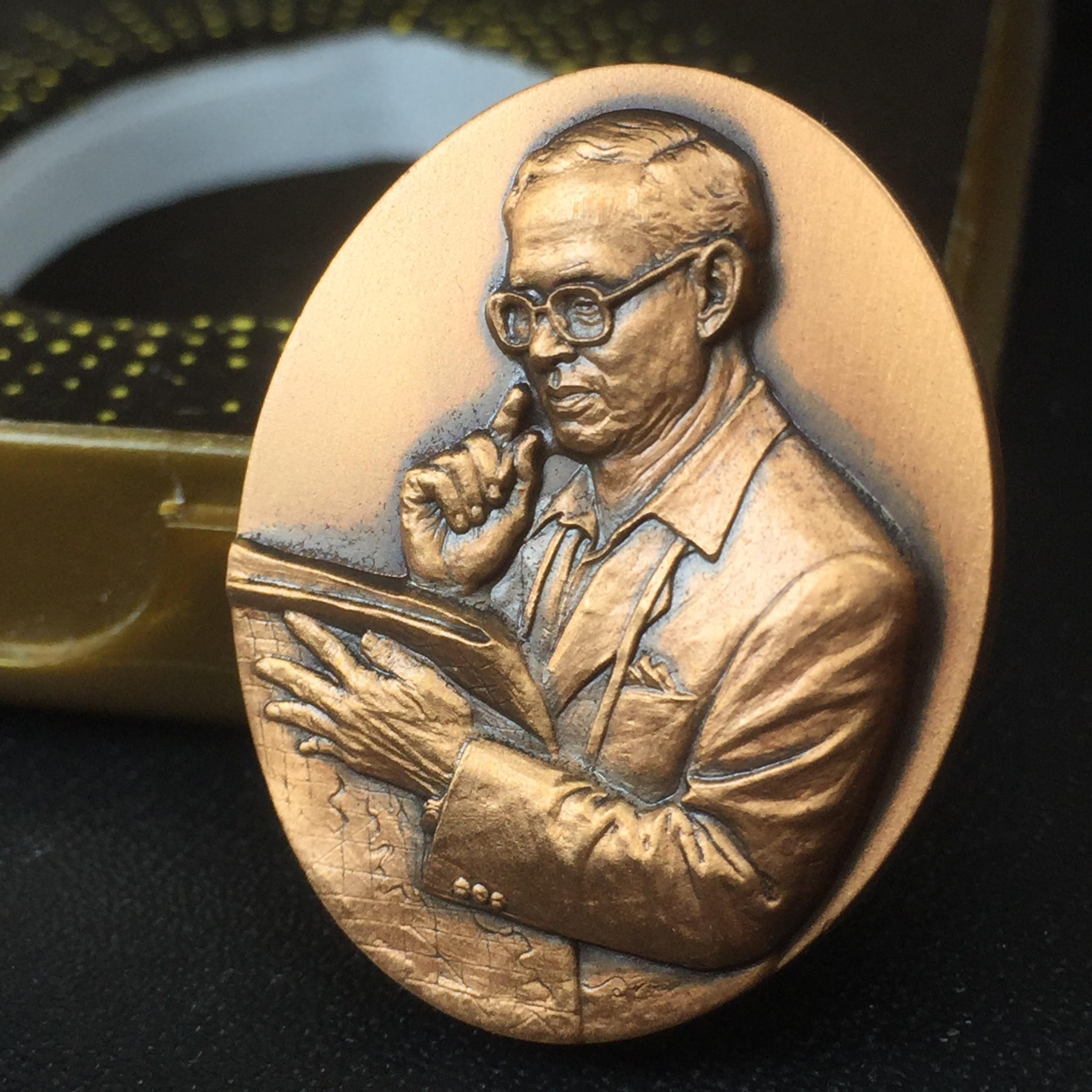 เหรียญรูปหล่อพระบาทสมเด็จพระเจ้าอยู่หัว ในหลวงทรงงาน “รุ่นเย็นศิระเพราะพระบริบาล 80พรรษา มหากษัตริย์คู่แผ่นดินสยาม” พ.ศ.2550 เนื้อทองแดงรมดำ(ขนาด 27*35 มม.)พร้อมกล่องบรรจุเดิมครบ