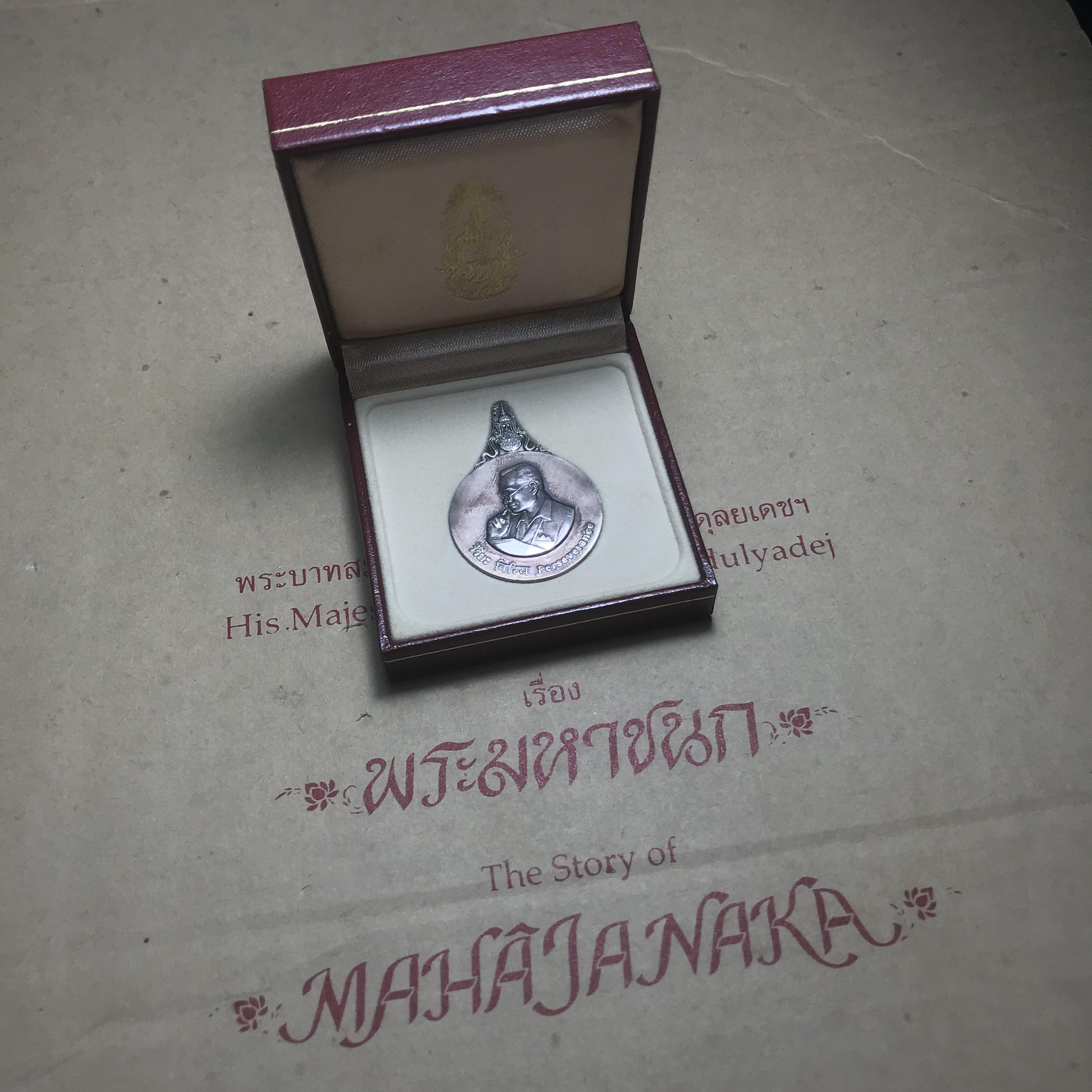 เหรียญพระมหาชนก ปี2539(รุ่นแรก) เนื้อเงิน พิมพ์ใหญ่บล็อกนิยม(ปอ ขาด) ผิวเดิมสีรุ้งธรรมชาติแบบนิยม พร้อมหนังสือสภาพสวยครบชุด(ในหลวงเสด็จเป็นประธานในพิธี)