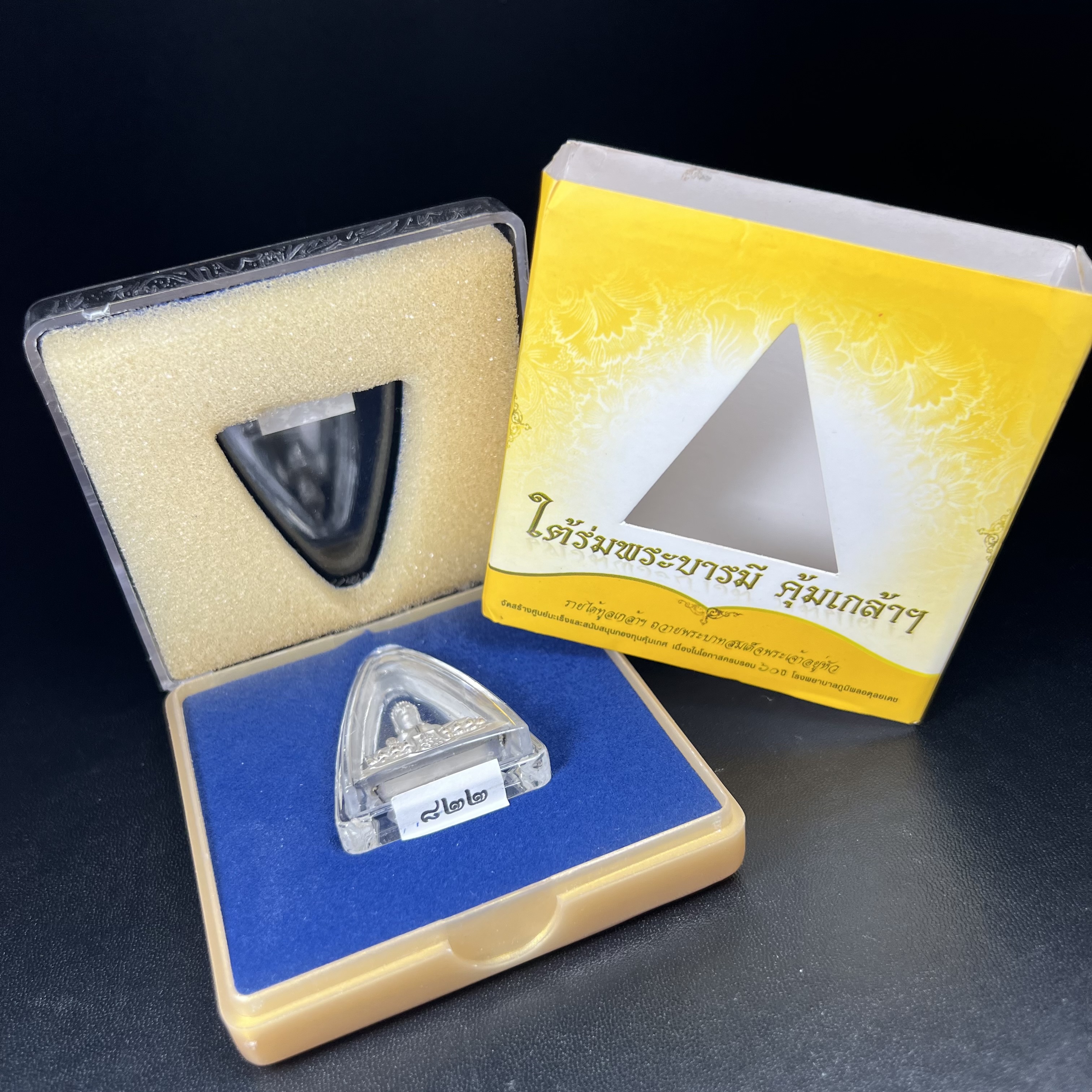 พระพุทธรูปคุ้มเกล้า ภปร.(ใต้ร่มพระบารมี คุ้มเกล้า) 60ปี โรงพยาบาลภูมิพลฯ พ.ศ.2552 เนื้อเงิน ชุบทองคำขาว(พิมพ์ใหญ่ขนาด 35.5*24 มม.)สภาพสวยเดิมพร้อมกล่องบรรจุเดิม ตอกโค๊ดหมายเลข ๘๒๒ หายาก(1ใน5000 องค์)