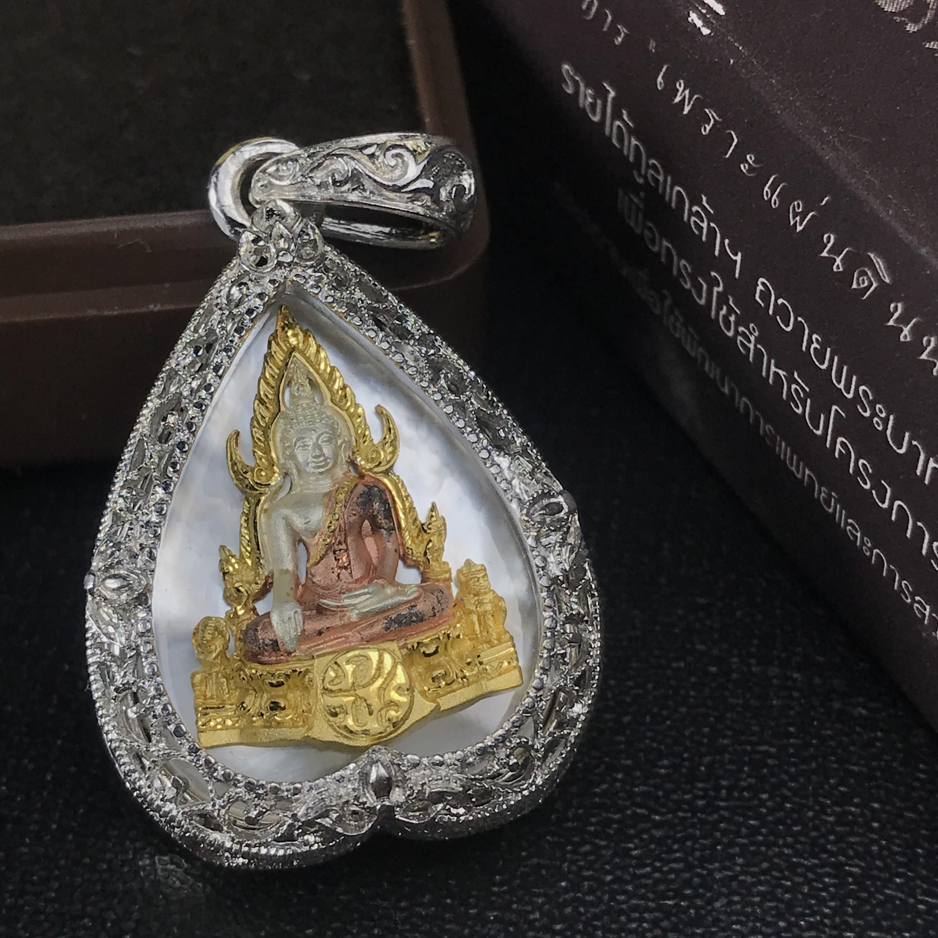 พระพุทธชินราช ภปร. โครงการ "เพราะแผ่นดินนี้ คือ แผ่นดินเกิด" ปี2548(รุ่นแรก) เหรียญทรงใบโพธิ์ ขนาด 21 x 29 มม. เนื้อเงินสามกษัตริย์ องค์พระชุบสามกษัตริย์ ล้อมด้วยกรอบเงินชุบทองคำขาวสลักเสลาเป็นลวดลายละเอียดอ่อน ส่วนพื้นองค์พระเป็นเปลือกหอยมุข