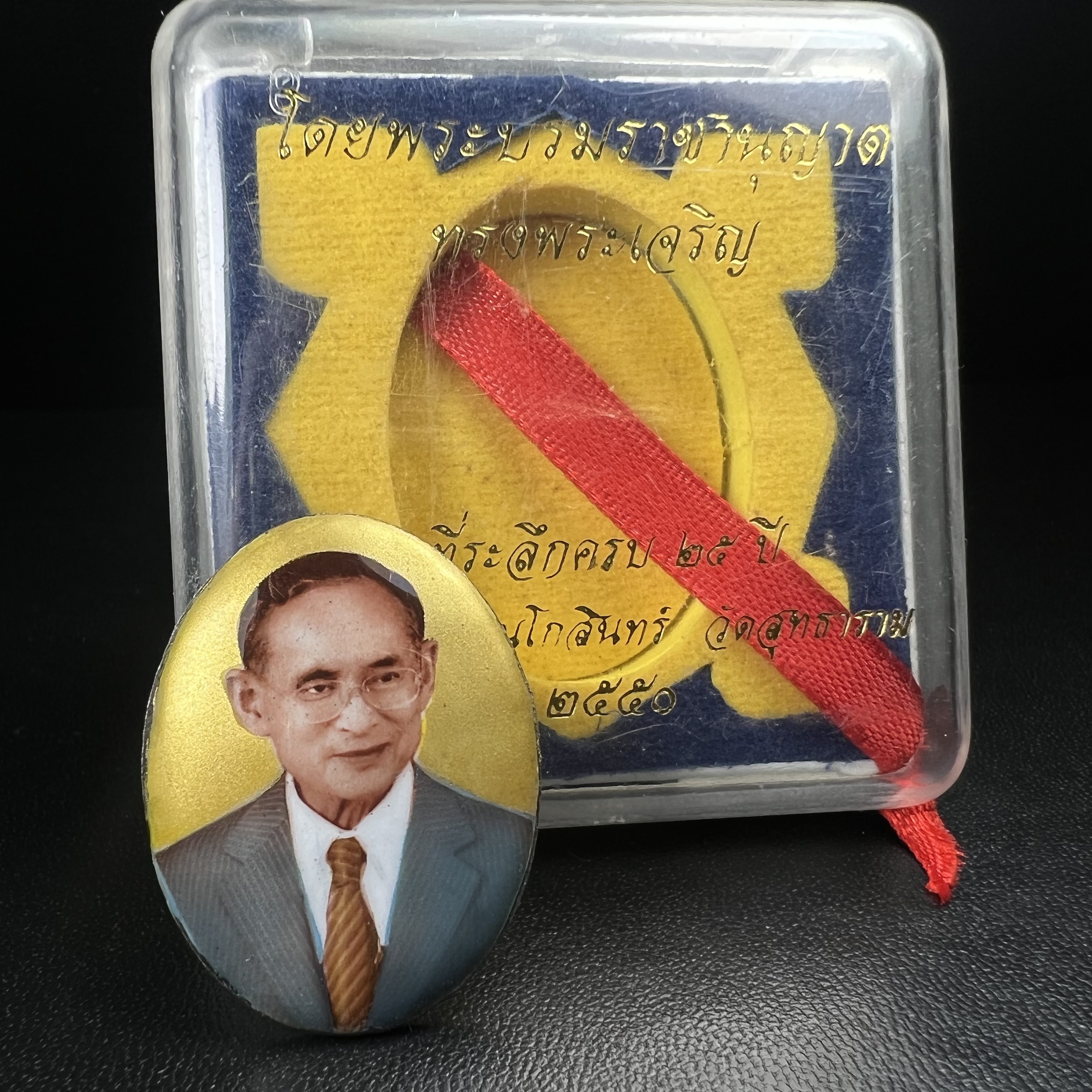 ล็อกเกตในหลวงรัชกาลที่9 ที่ระลึกครบ 25 ปี มูลนิธิศรีรัตนโกสินทร์ วัดสุทธาราม พ.ศ. 2550 พิมพ์ทรงวงรีรูปไข่เล็กฉากสีทอง หลังปิดแผ่นโลหะสีขาว(สแตนเลส)ฝังพระยอดธง(นิยม)