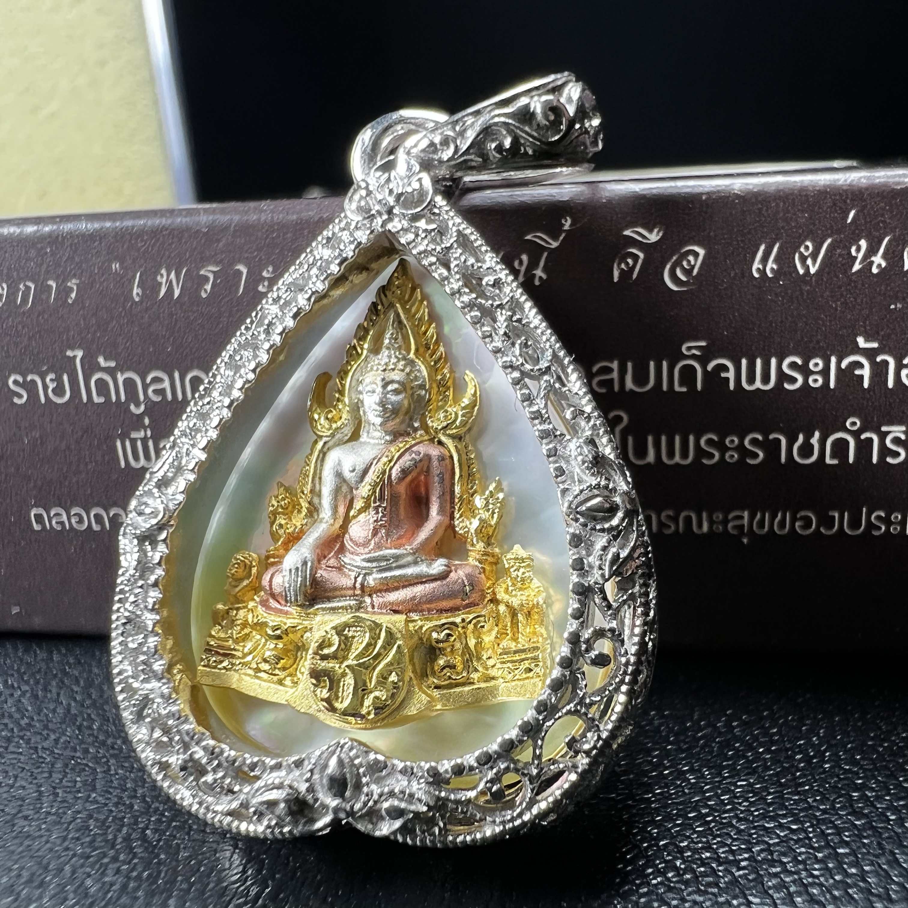 พระพุทธชินราช ภปร. โครงการ "เพราะแผ่นดินนี้ คือ แผ่นดินเกิด" ปี2548(รุ่นแรก) เหรียญทรงใบโพธิ์ ขนาด 21 x 29 มม. เนื้อเงินสามกษัตริย์ องค์พระชุบสามกษัตริย์ ล้อมด้วยกรอบเงินชุบทองคำขาวสลักเสลาเป็นลวดลายละเอียดอ่อน ส่วนพื้นองค์พระเป็นเปลือกหอยมุข
