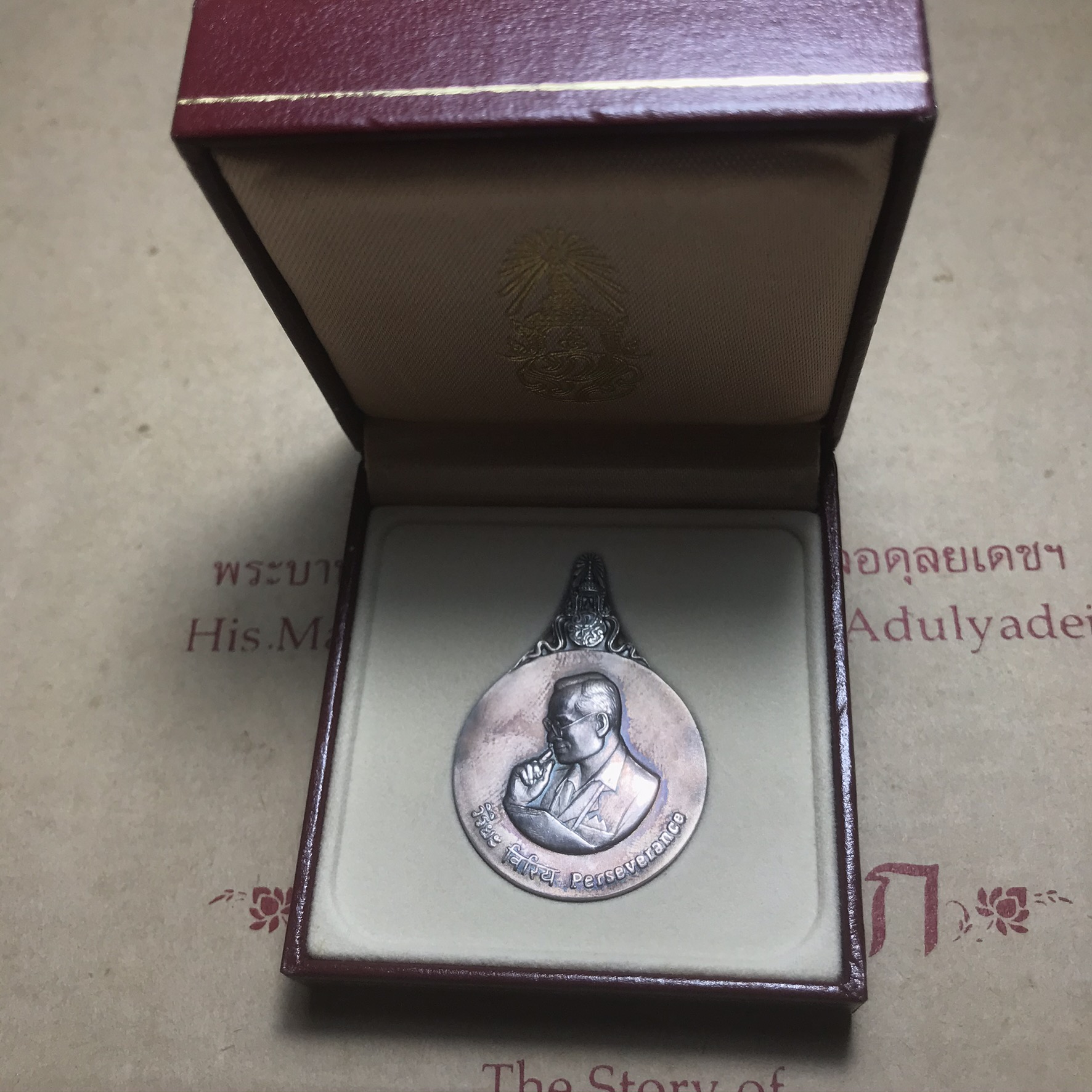 เหรียญพระมหาชนก ปี2539(รุ่นแรก) เนื้อเงิน พิมพ์ใหญ่บล็อกนิยม(ปอ ขาด) ผิวเดิมสีรุ้งธรรมชาติแบบนิยม พร้อมหนังสือสภาพสวยครบชุด(ในหลวงเสด็จเป็นประธานในพิธี)