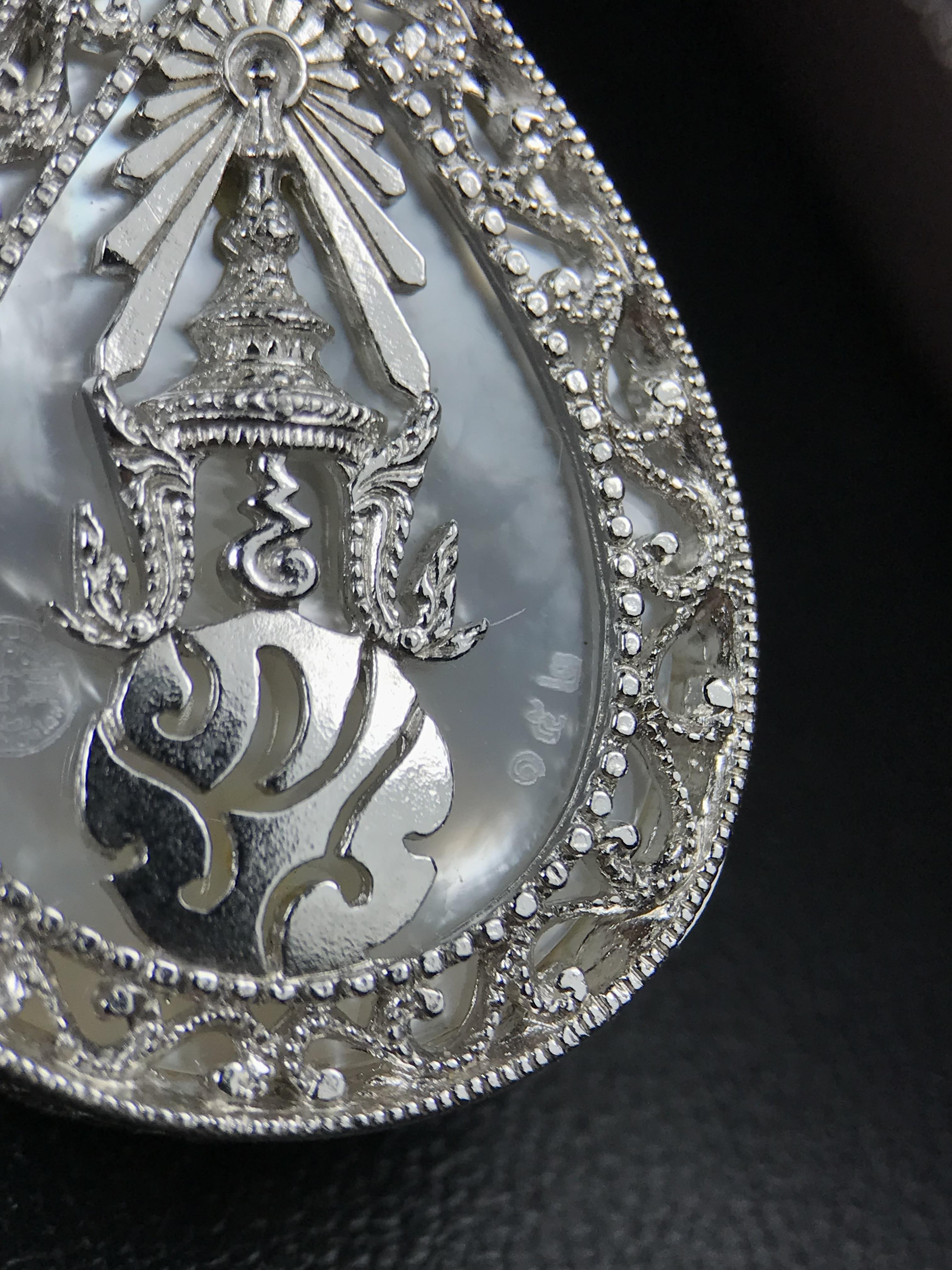 พระพุทธชินราช ภปร. โครงการ "เพราะแผ่นดินนี้ คือ แผ่นดินเกิด" ปี 2548(รุ่นแรก) เหรียญทรงหยดน้ำ ขนาด 21 x 31 มม. เนื้อเงินสามกษัตริย์ องค์พระชุบสามกษัตริย์ ล้อมด้วยกรอบเงินชุบทองคำขาวสลักเสลาเป็นลวดลายละเอียดอ่อน ส่วนพื้นองค์พระเป็นเปลือกหอยมุข