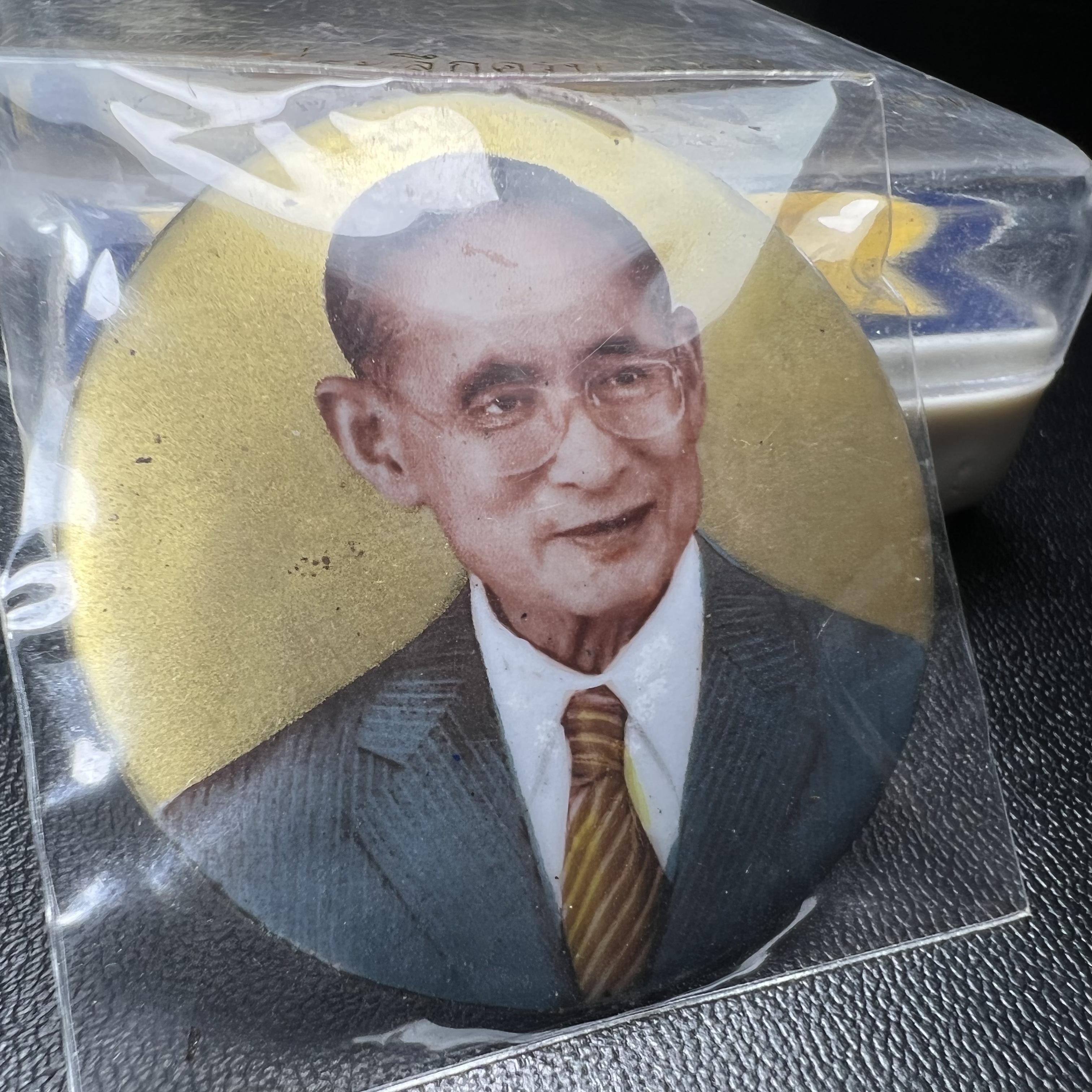 ล็อกเกตในหลวงรัชกาลที่9 ที่ระลึกครบ 25 ปี มูลนิธิศรีรัตนโกสินทร์ วัดสุทธาราม พ.ศ. 2550 พิมพ์ทรงกลมฉากสีทอง หลังปิดแผ่นโลหะสีขาว(สแตนเลส)ฝังพระยอดธง(นิยม)