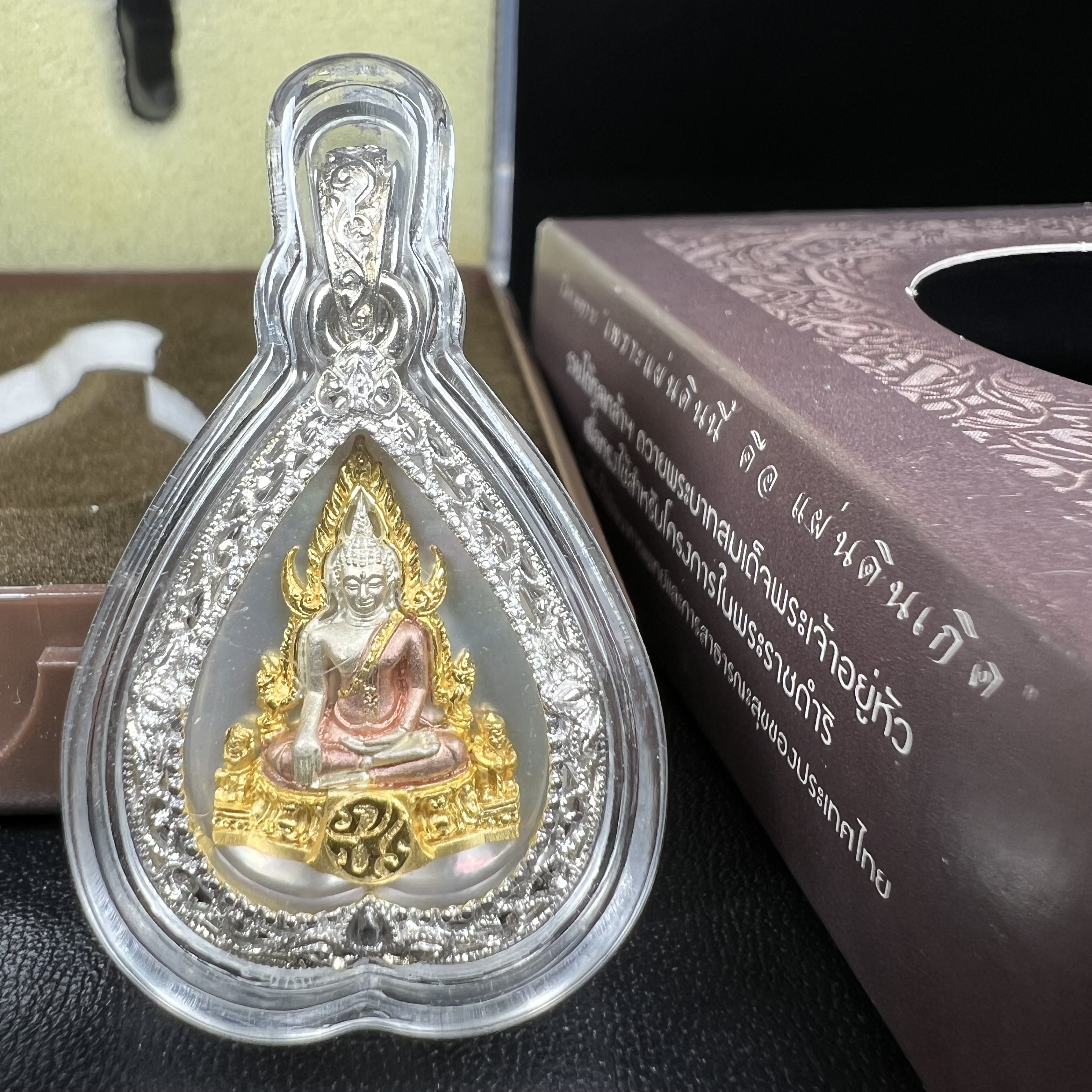 พระพุทธชินราช ภปร. โครงการ "เพราะแผ่นดินนี้ คือ แผ่นดินเกิด" ปี2548(รุ่นแรก) เหรียญทรงใบโพธิ์ ขนาด 21 x 29 มม. เนื้อเงินสามกษัตริย์ องค์พระชุบสามกษัตริย์ ล้อมด้วยกรอบเงินชุบทองคำขาวสลักเสลาเป็นลวดลายละเอียดอ่อน ส่วนพื้นองค์พระเป็นเปลือกหอยมุข