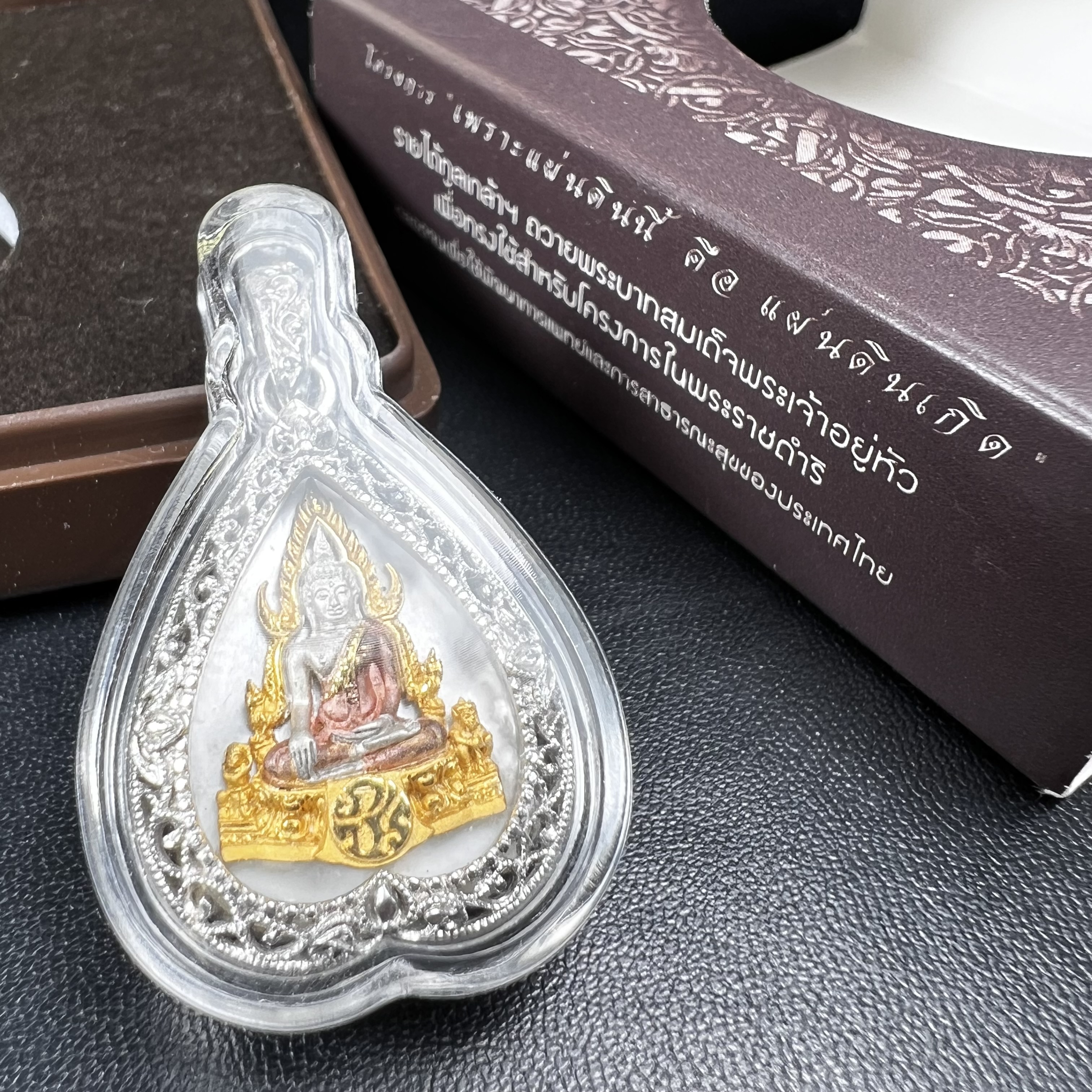 พระพุทธชินราช ภปร. โครงการ "เพราะแผ่นดินนี้ คือ แผ่นดินเกิด" ปี 2548(รุ่นแรก) เหรียญทรงใบโพธิ์ ขนาด 21 x 29 มม. เนื้อเงินสามกษัตริย์ องค์พระชุบสามกษัตริย์ ล้อมด้วยกรอบเงินชุบทองคำขาวสลักเสลาเป็นลวดลายละเอียดอ่อน ส่วนพื้นองค์พระเป็นเปลือกหอยมุข