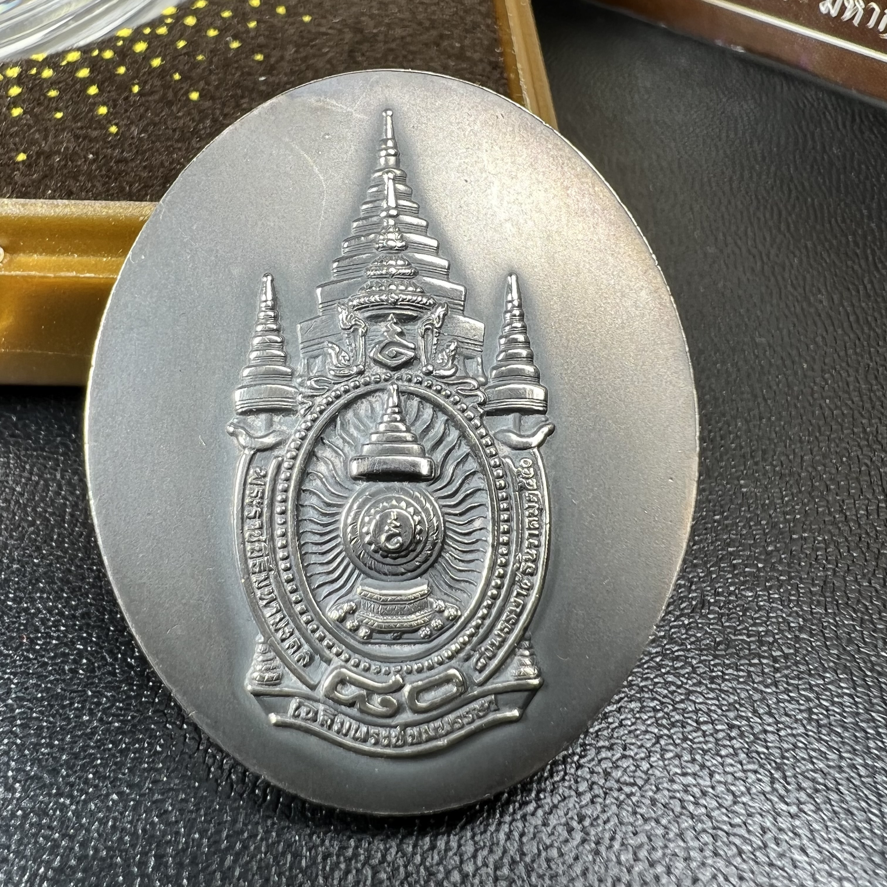 เหรียญรูปหล่อพระบาทสมเด็จพระเจ้าอยู่หัว ในหลวงทรงงาน “รุ่นเย็นศิระเพราะพระบริบาล 80พรรษา มหากษัตริย์คู่แผ่นดินสยาม” พ.ศ.2550 เนื้อเงินรมดำ(ขนาด 27*35 มม.) พร้อมกล่องบรรจุเดิมครบ