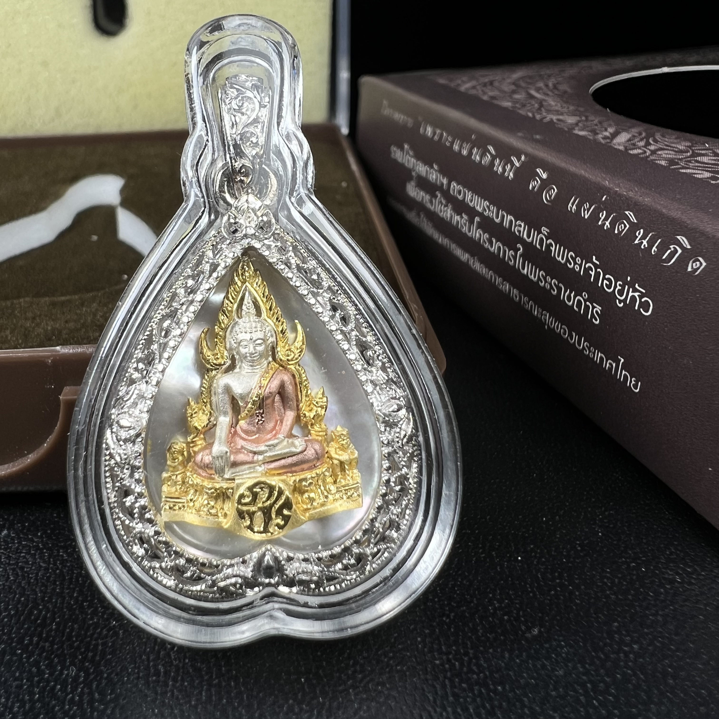 พระพุทธชินราช ภปร. โครงการ "เพราะแผ่นดินนี้ คือ แผ่นดินเกิด" ปี2548(รุ่นแรก) เหรียญทรงใบโพธิ์ ขนาด 21 x 29 มม. เนื้อเงินสามกษัตริย์ องค์พระชุบสามกษัตริย์ ล้อมด้วยกรอบเงินชุบทองคำขาวสลักเสลาเป็นลวดลายละเอียดอ่อน ส่วนพื้นองค์พระเป็นเปลือกหอยมุข