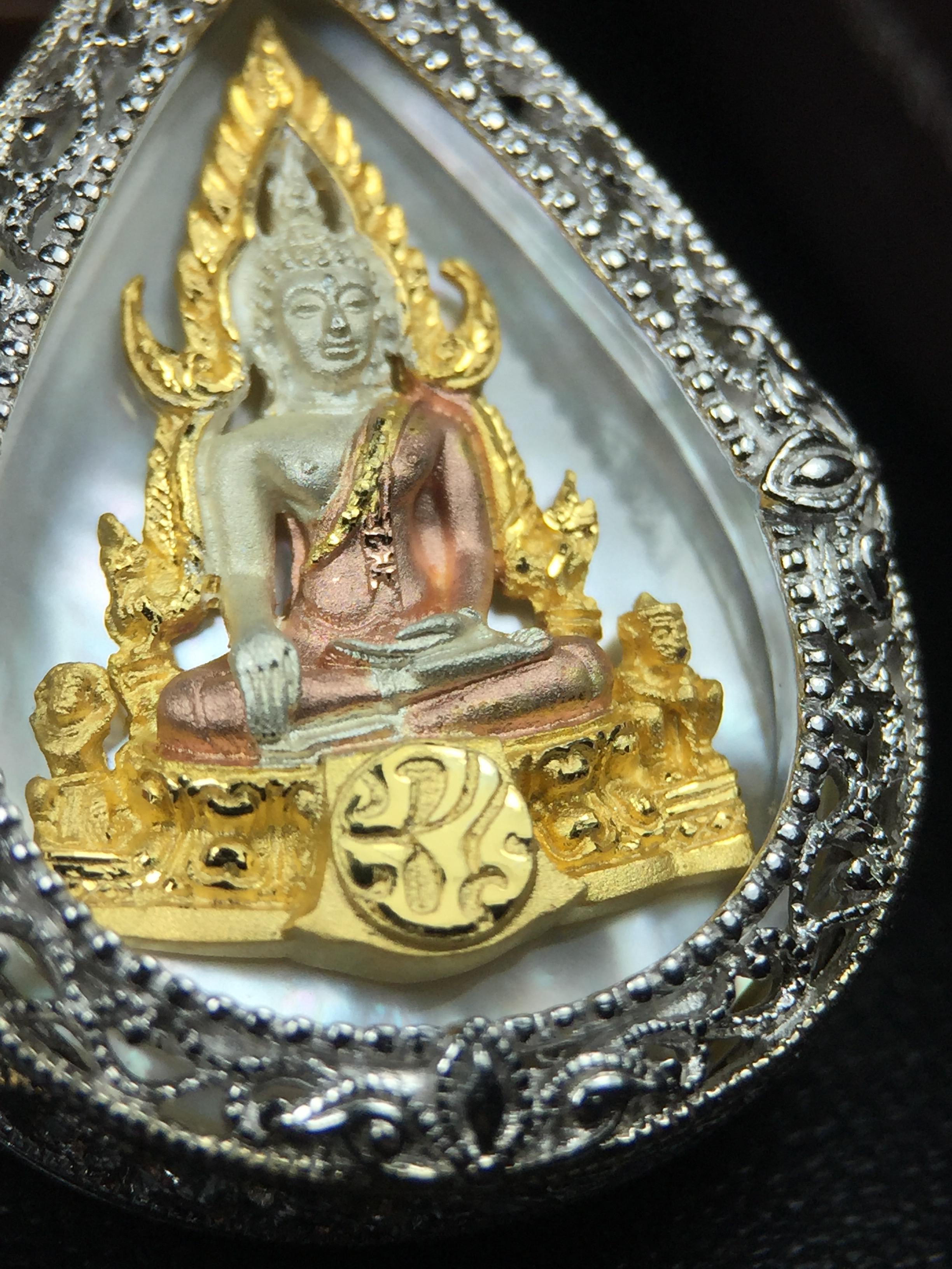 พระพุทธชินราช ภปร. โครงการ "เพราะแผ่นดินนี้ คือ แผ่นดินเกิด" ปี2548(รุ่นแรก) เหรียญทรงหยดน้ำ ขนาด 21 x 31 มม. เนื้อเงินสามกษัตริย์ องค์พระชุบสามกษัตริย์ ล้อมด้วยกรอบเงินชุบทองคำขาวสลักเสลาเป็นลวดลายละเอียดอ่อน ส่วนพื้นองค์พระเป็นเปลือกหอยมุข